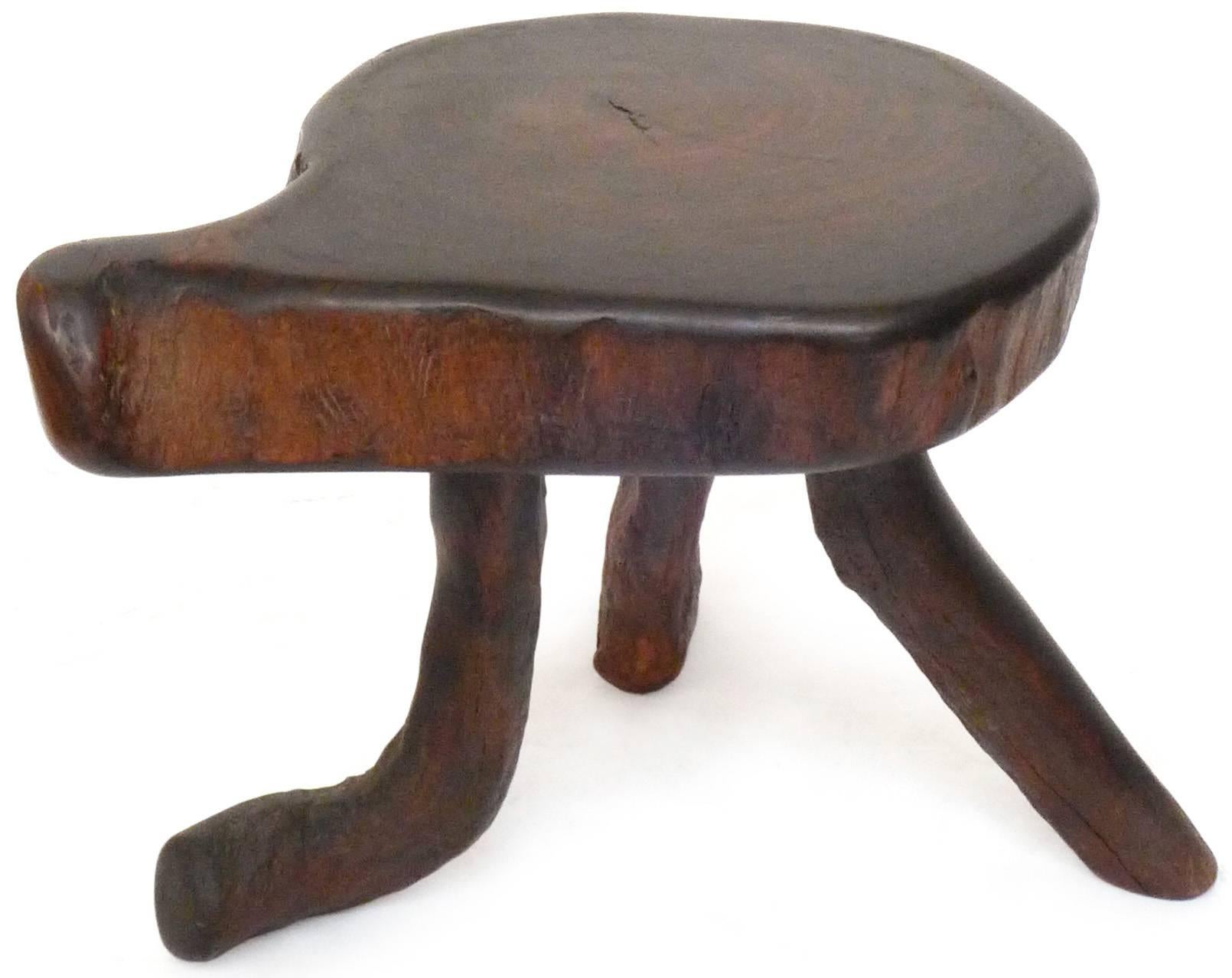 A wonderful pair of organic wood stools or side tables. Compact, three-legged, asymmetrical forms replete with fantastic free-edge and natural texture details, wearing a rich, dark-walnut patina. Pleasingly well-built and sturdy. Great scale and