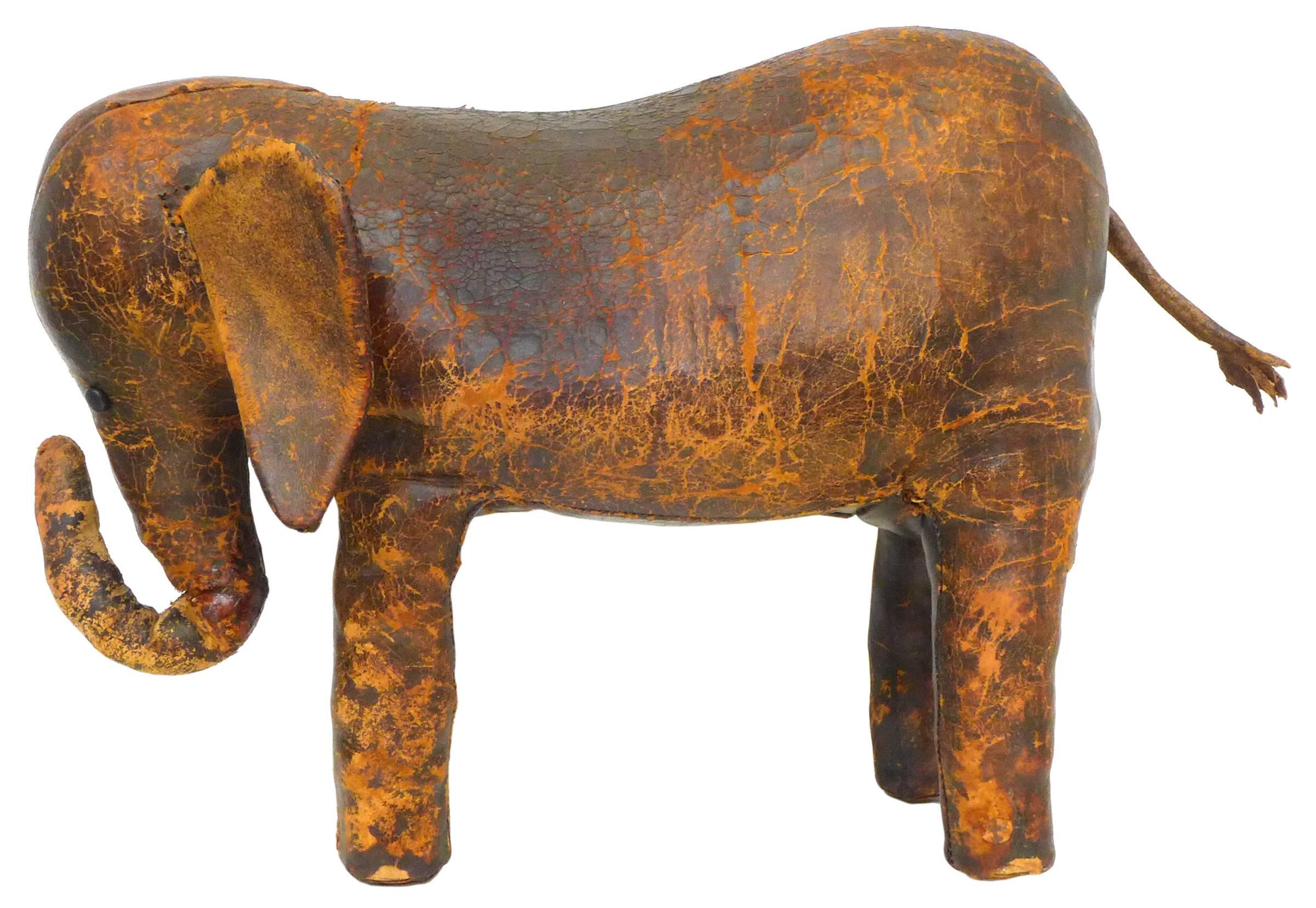 A wonderfully worn, leather elephant footstool. Clearly of the period and after or possibly by Dimitri Omersa for Abercrombie and Fitch. A playful and iconic item with an unusually even, exceptionally distressed patina, exuding great decorative