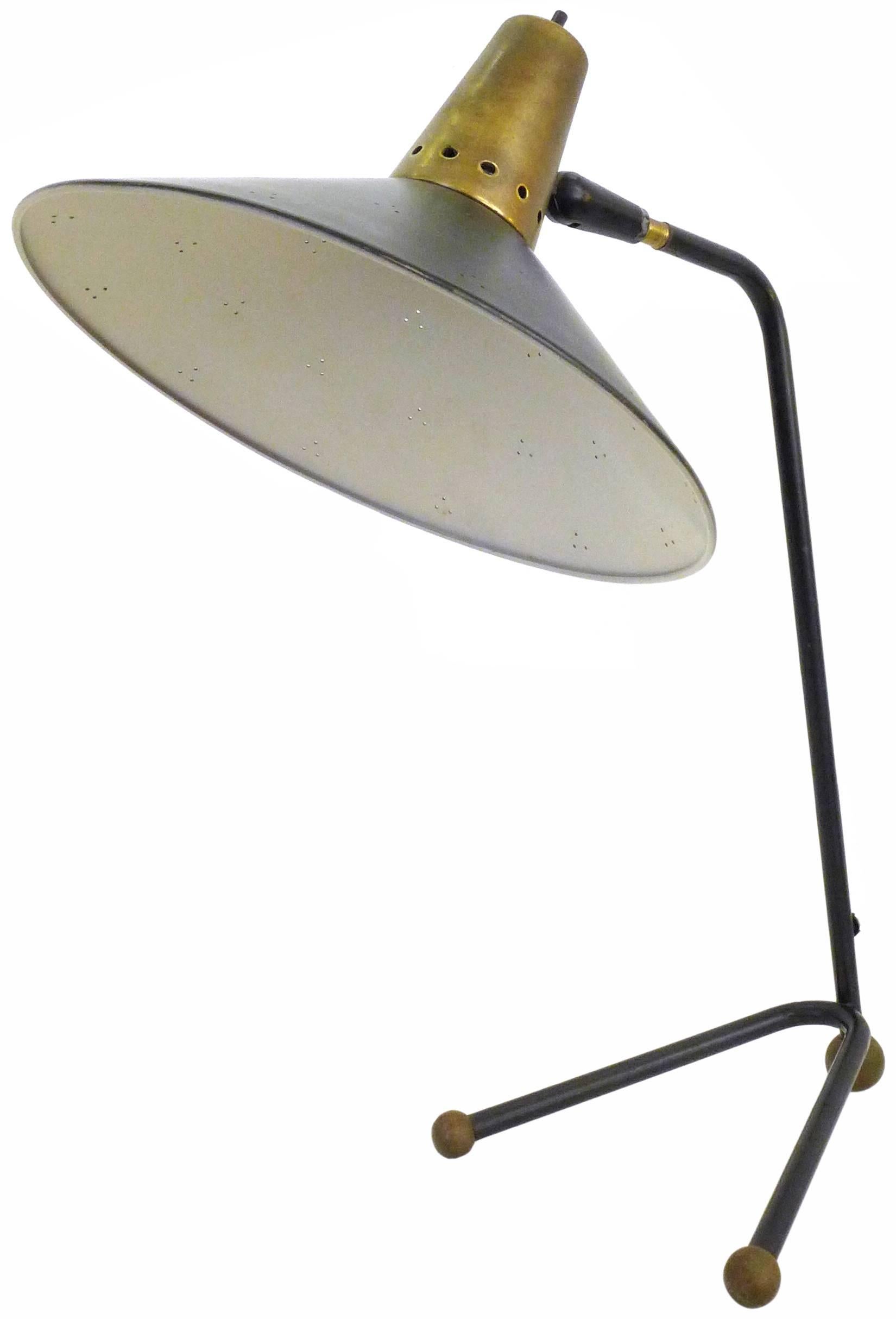 A fantastic Mid-Century task lamp. Presented in black and brass, a decoratively perforated, articulated, 