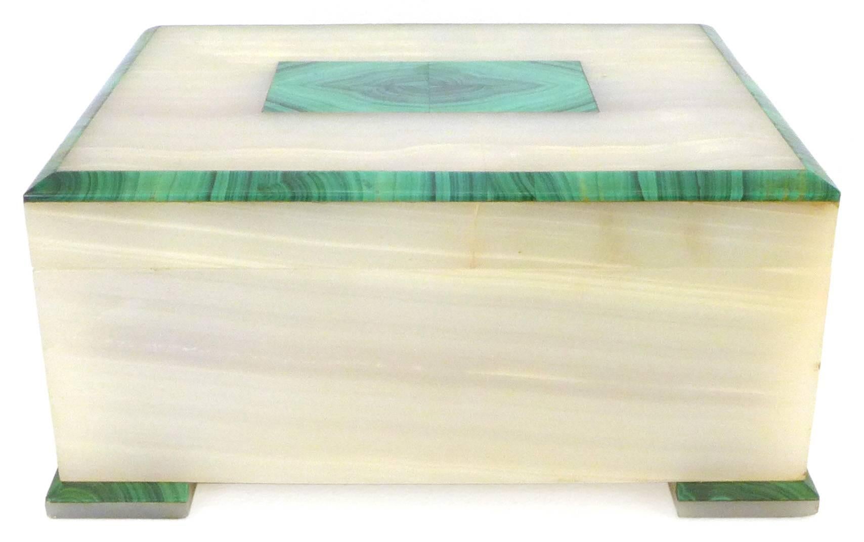 An exceptional malachite and onyx box produced by Dunhill London sometime in the 1930s. Wonderful scale, construction, mix of exotic stone and Classic Art Deco lines. A massive and chunky box likely for cigars, with a beautiful wood liner and a