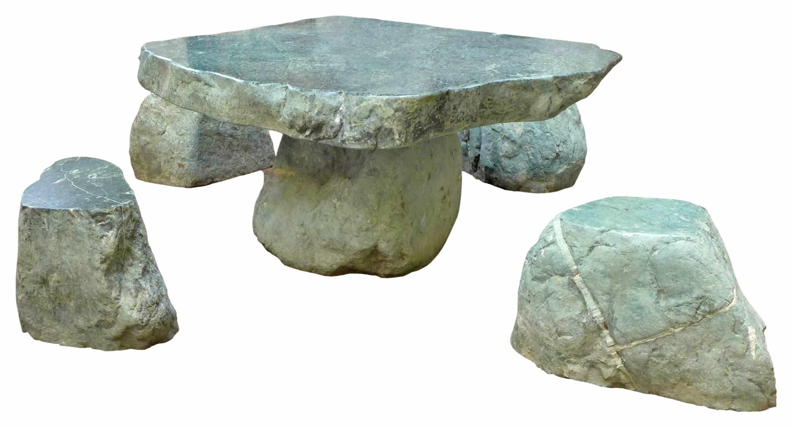 An incredible, low, organic table and stools set in a lush, green granite. A fantastic grouping of wonderfully unexpected scale, form and material; a low, free-edge, thick-slab-top table surrounded by four, variously-sized, free-edge 
