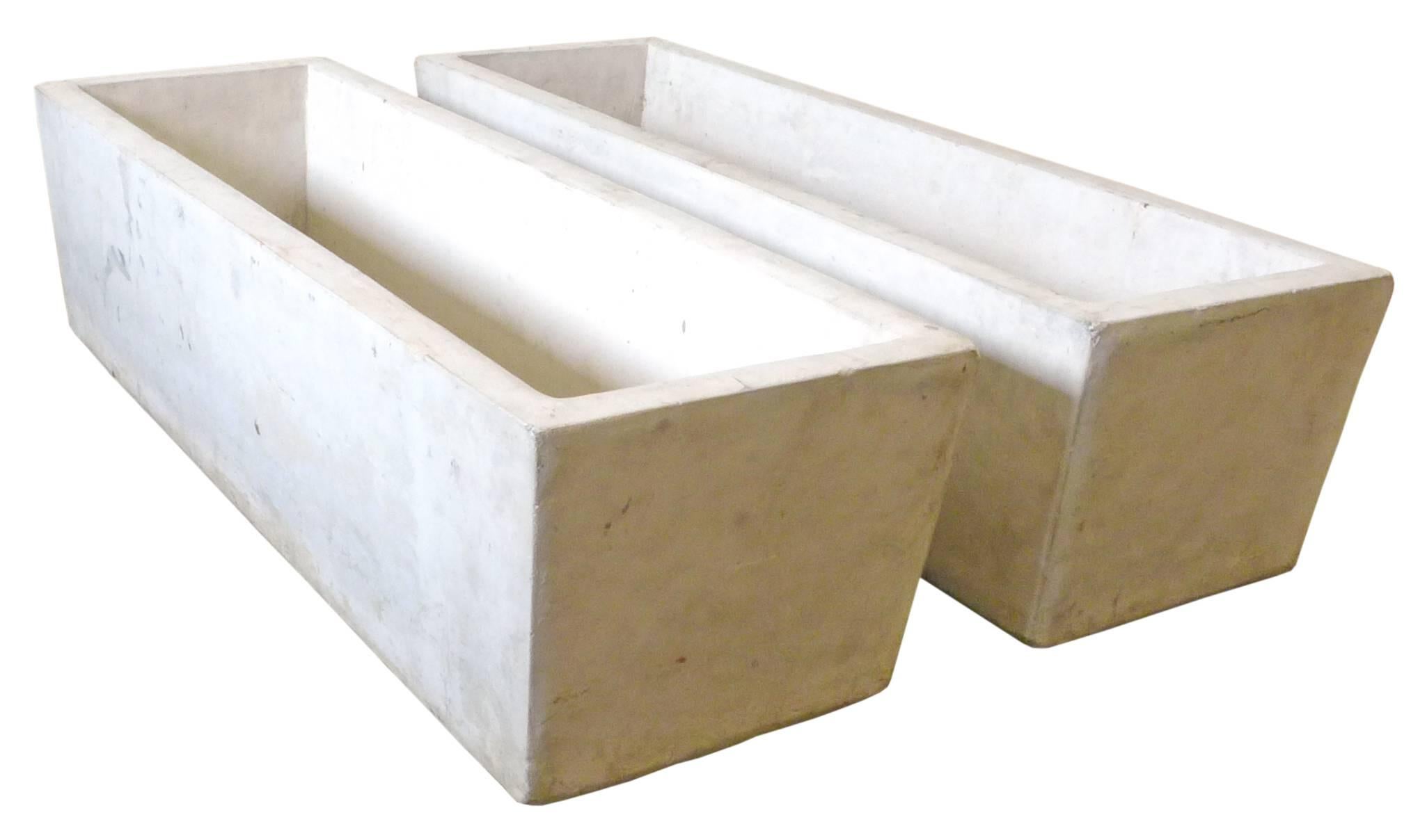 A fantastic pair of architectural, cast-stone planters. Substantial, thick-walled, trapezoidal forms in a pale oatmeal hue. A classic garden element, an impressive matched pair great for use indoors or out.
