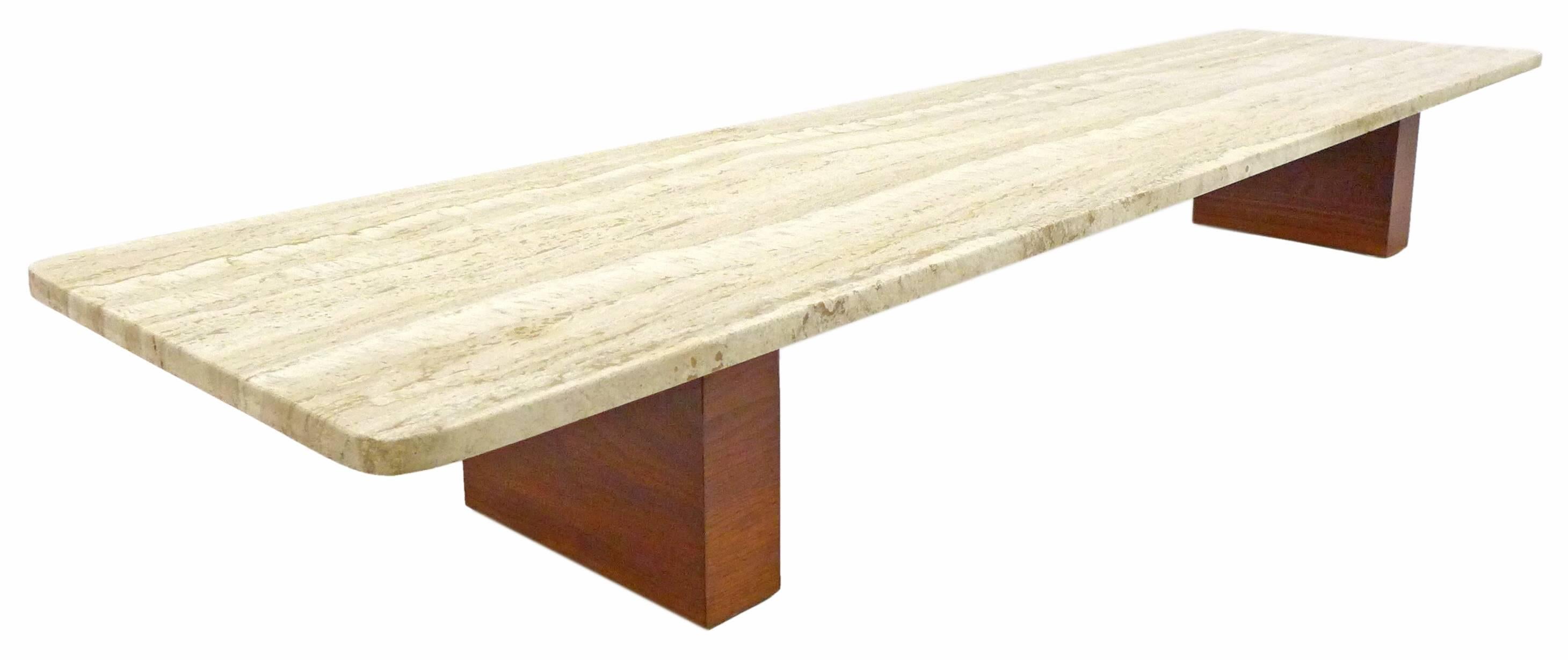 A spectacular and unusual low coffee table of travertine and wood.  Evoking a Japanese aesthetic in both scale and beauty-in-simplicity, a long travertine slab with radiused corners, wearing wonderfully-pronounced grain resting atop an austere,