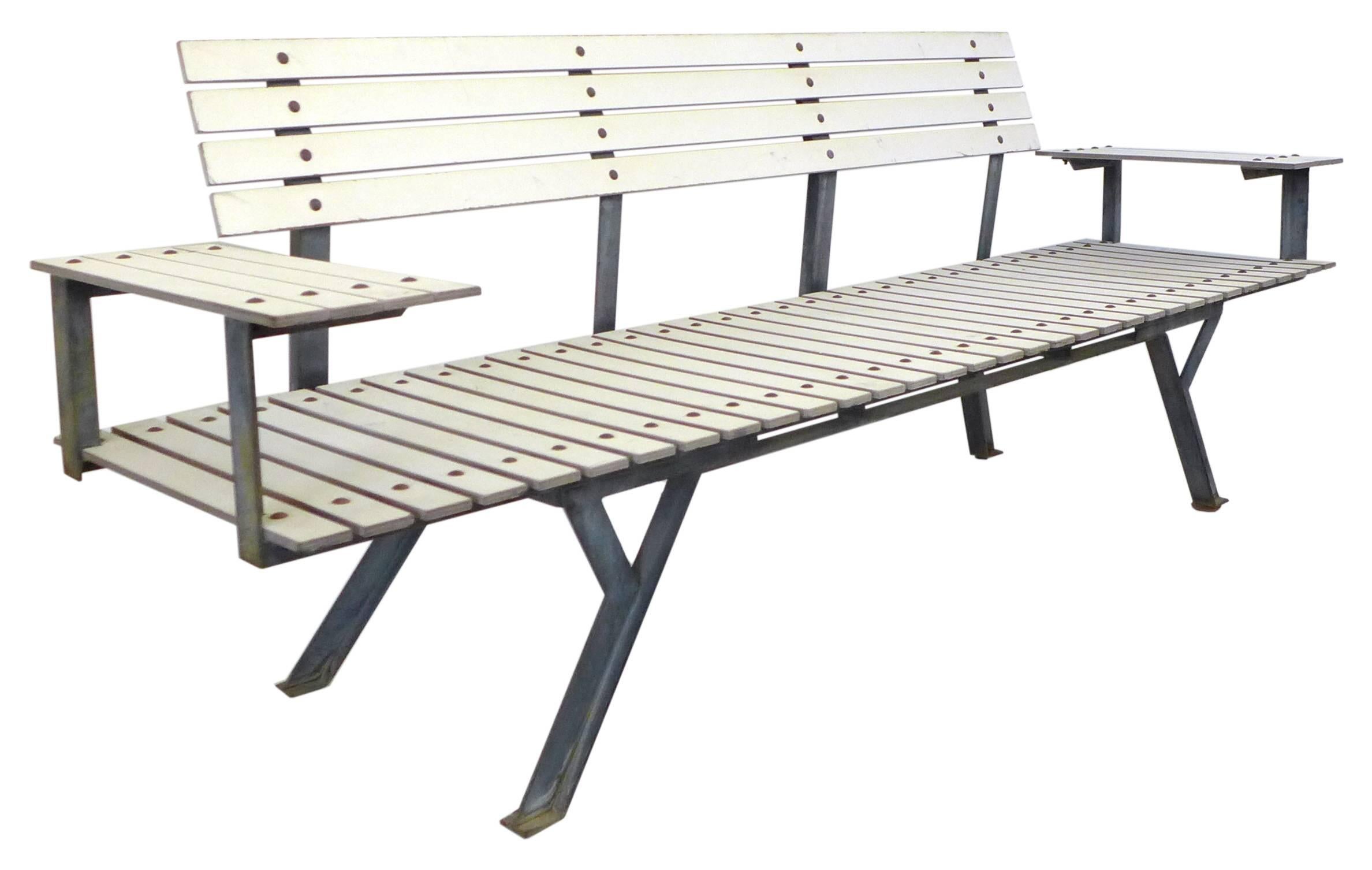 A very unusual and architecturally inspired slat bench of steel and painted wood slats. An extremely interesting and angular leg structure and frame system support a graphically powerful yet simple pattern of wooden slats. Two floating and slatted