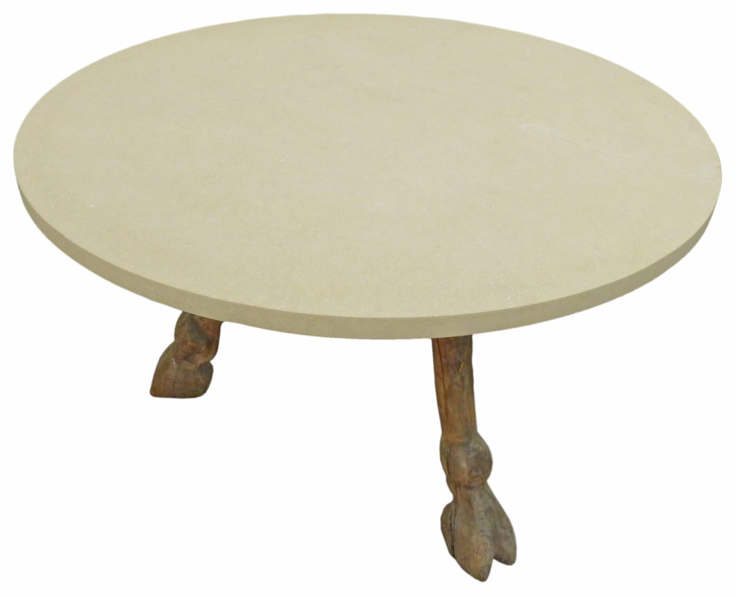 A wonderful and unusual three-legged, cloven-hoof, round-top dining table of limestone and wood. A beautifully carved, pre-war table base embodying a perfect blend of primitivity and elegance; a masculine Americana with even a tinge of the occult;