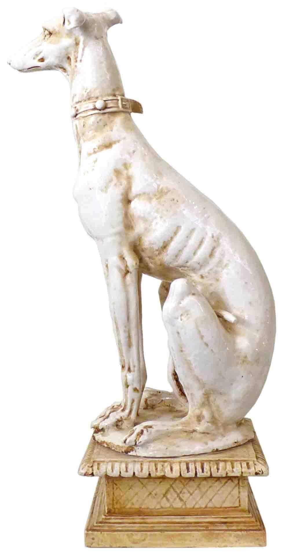 An outstanding pair of Italian, glazed terracotta, greyhound statues.  Perfectly pedestal-perched, realistic and life-size representations of these regal creatures, simultaneously austere, alert, and obedient.  Subtly-differing, near-mirror imaging