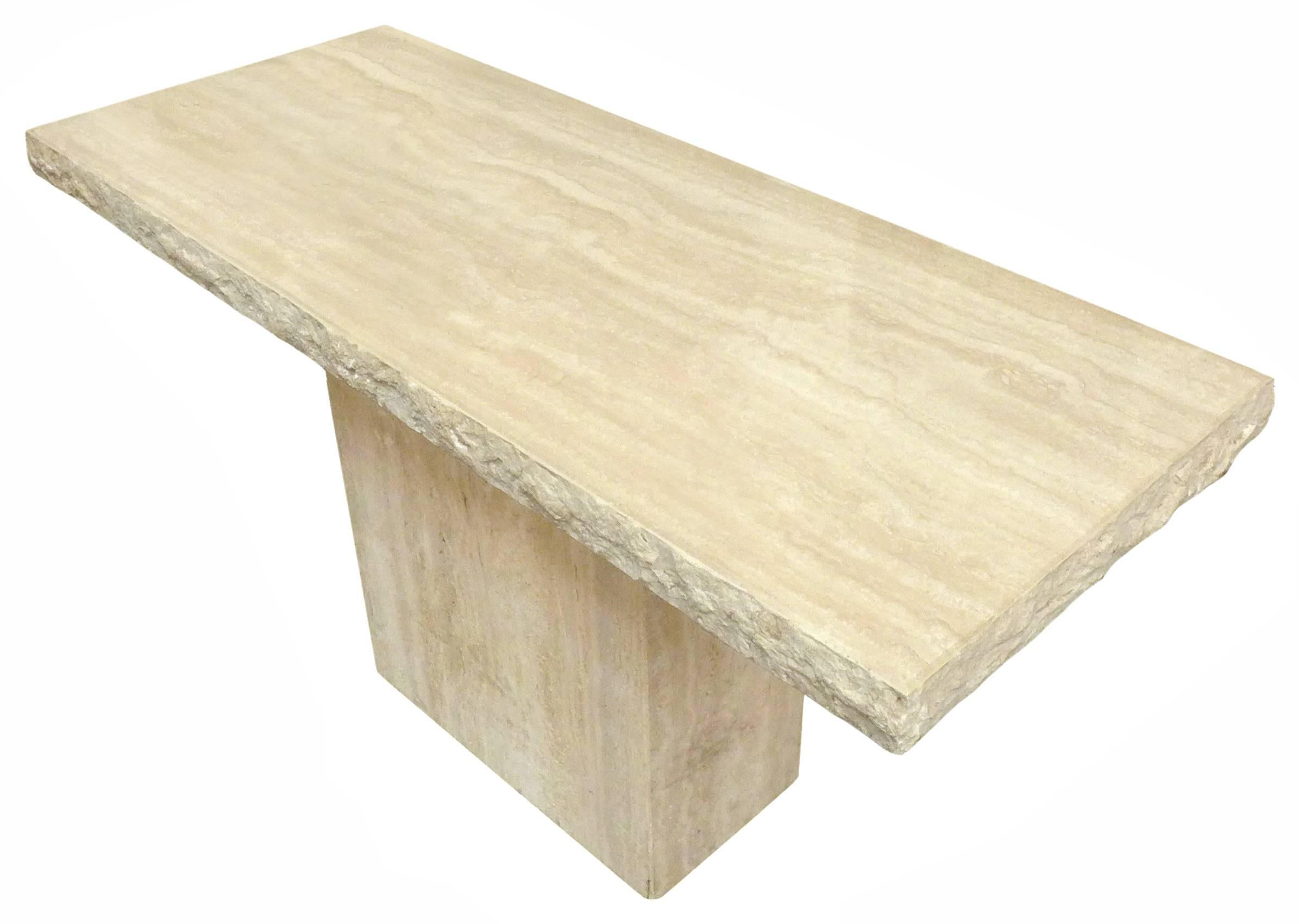A fantastic and massive travertine console table with beautiful, rough-hewn edge detail. Classic, polished travertine grain and oatmeal hue. A wonderfully simple and powerful utilitarian piece.