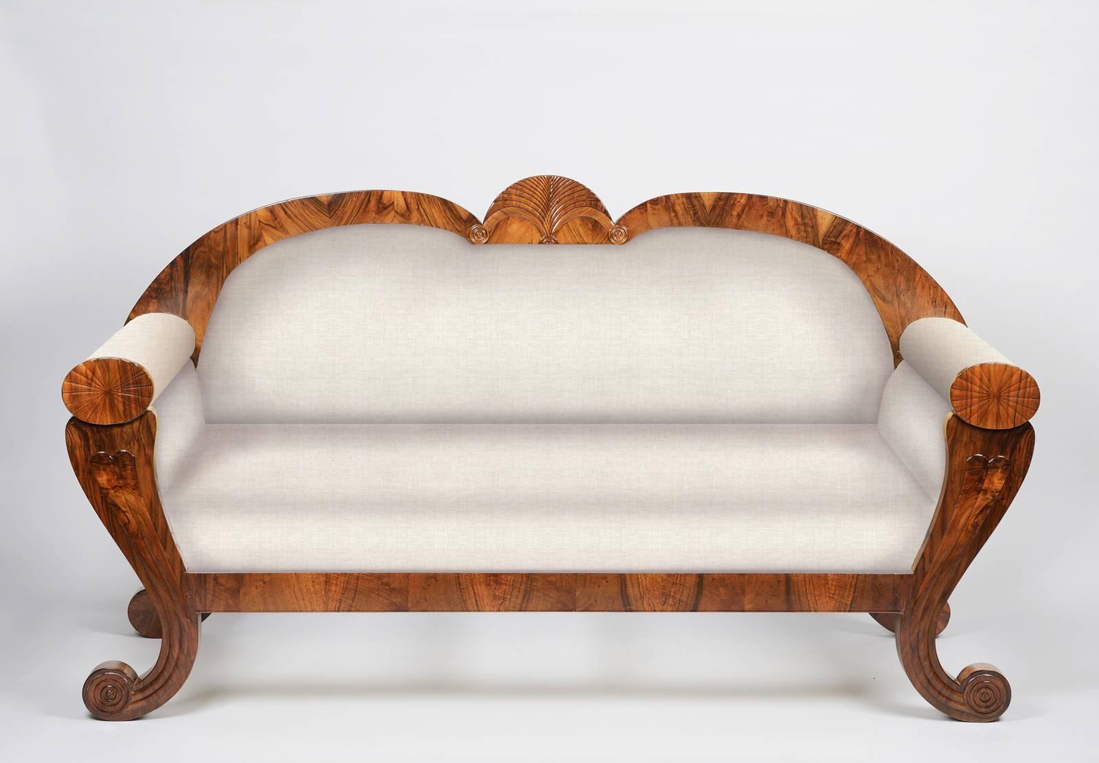 An exceptional neo-Egyptian style Biedermeier sofa in vivid walnut veneer, with elegant scrolled volute legs with carved acanthus and applied walnut detailing,
Vienna, circa 1830.