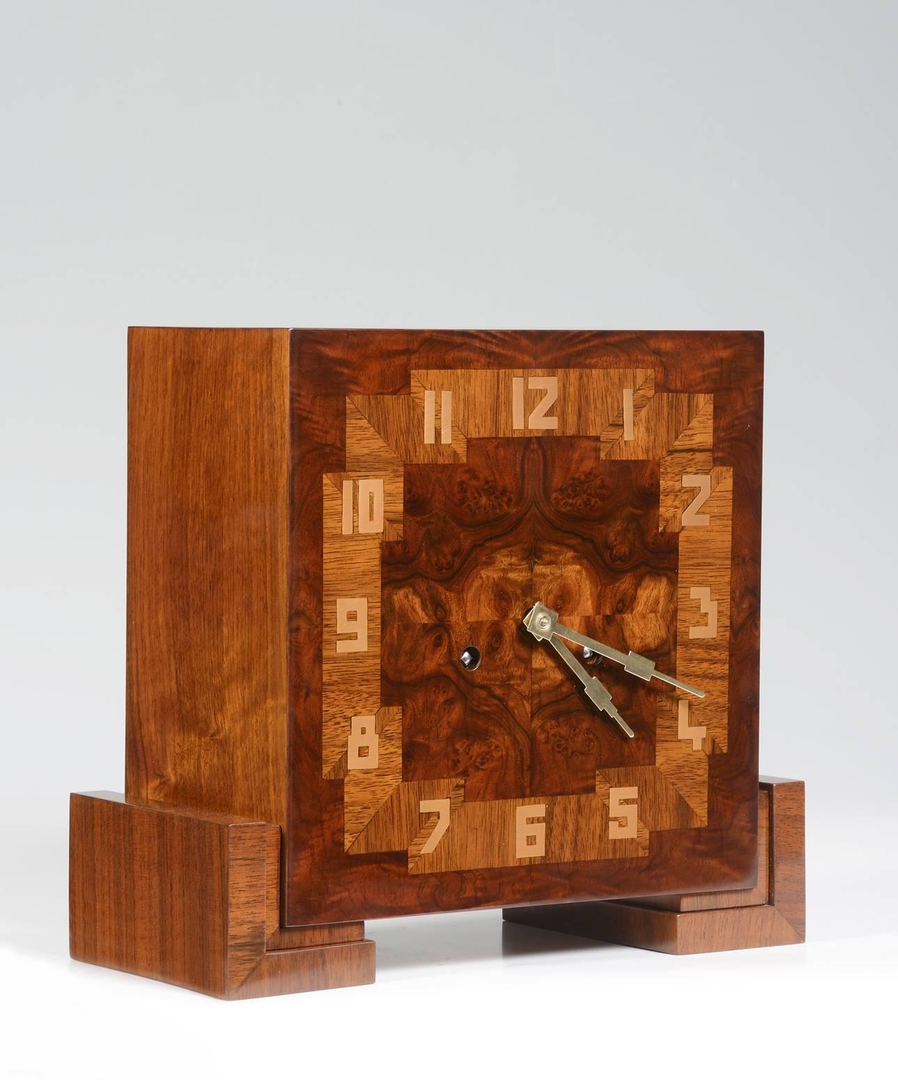 Burl walnut veneer with fruit wood inlays. Brass numerals and 3 day movement.
By Hartmut Moller.