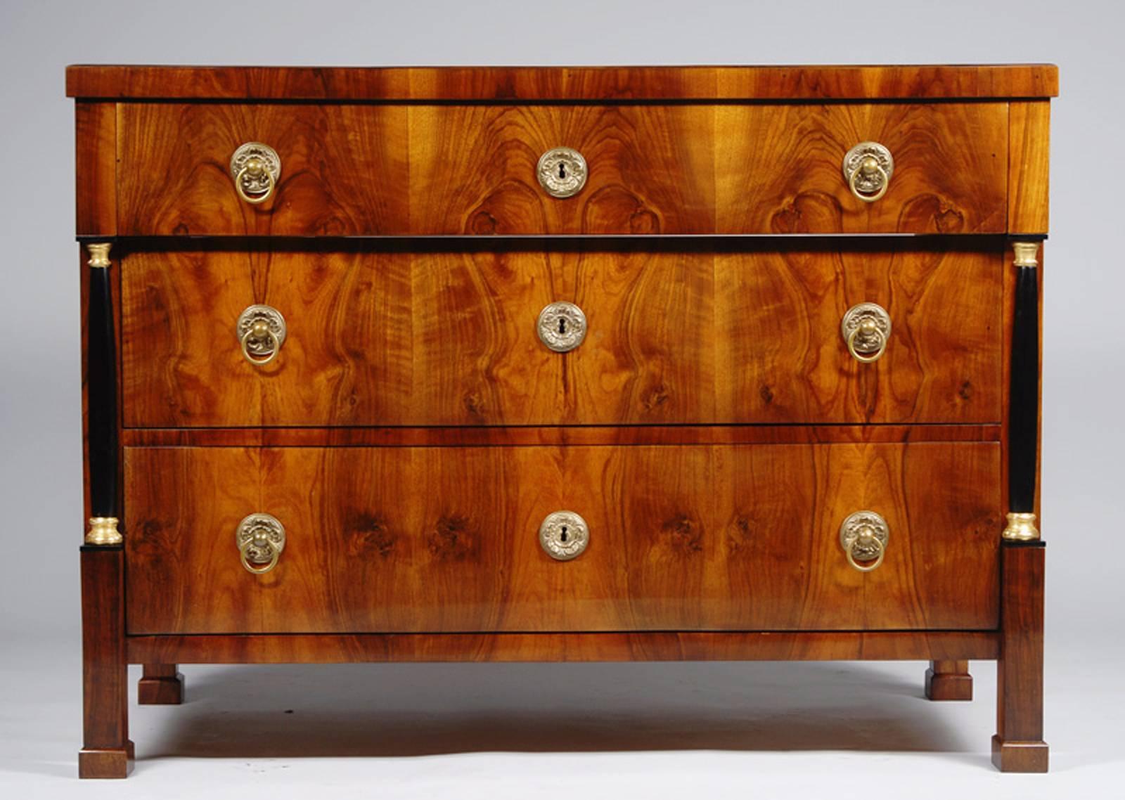 Bookmatched walnut veneer with engaged ebonized columns with gilt capitals.