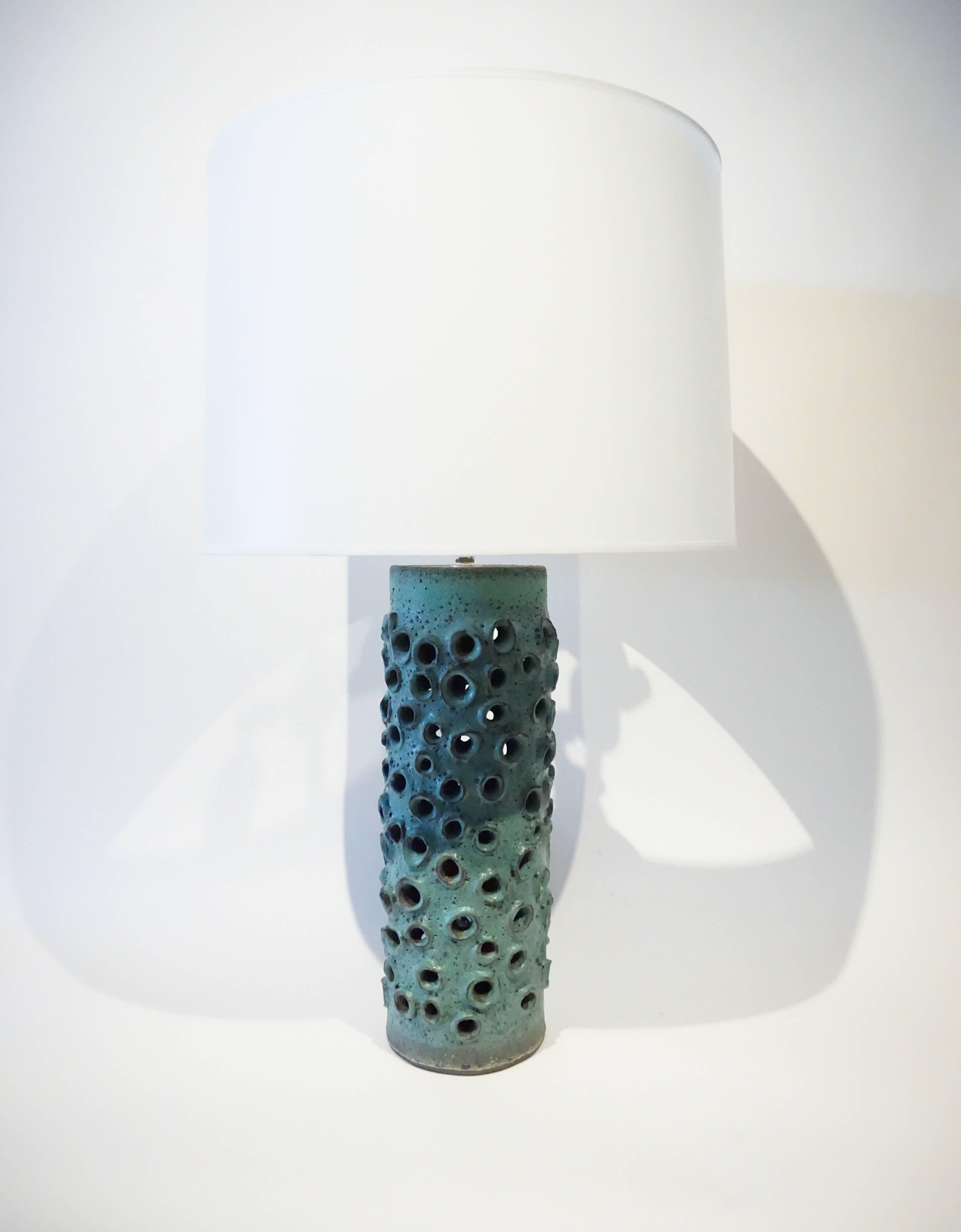 A hand-made turquoise-glazed pottery table lamp, made for Christopher Anthony Ltd. by American studio ceramicist Warner Walcott. C. 2016. Randomly spaced openings populate the body of the lamp and the thickly glazed surface references works produced