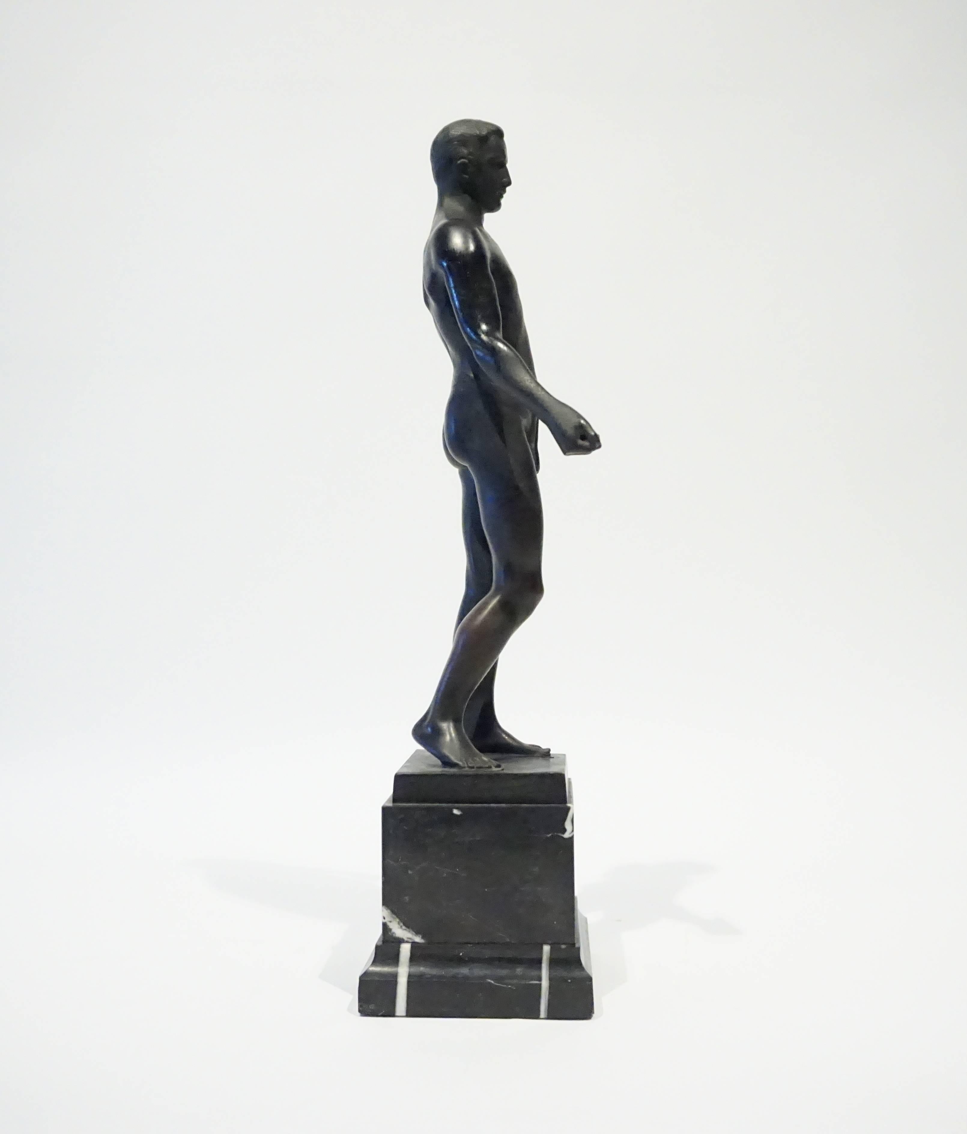 A patinated bronze figure of a male athlete standing on a classical black marble base by German sculptor Ferdinand Frick. C. 1910. Signed on the bronze base Ferd. Frick fec.  Also signed by the foundry: Oskar Gladenbeck and 