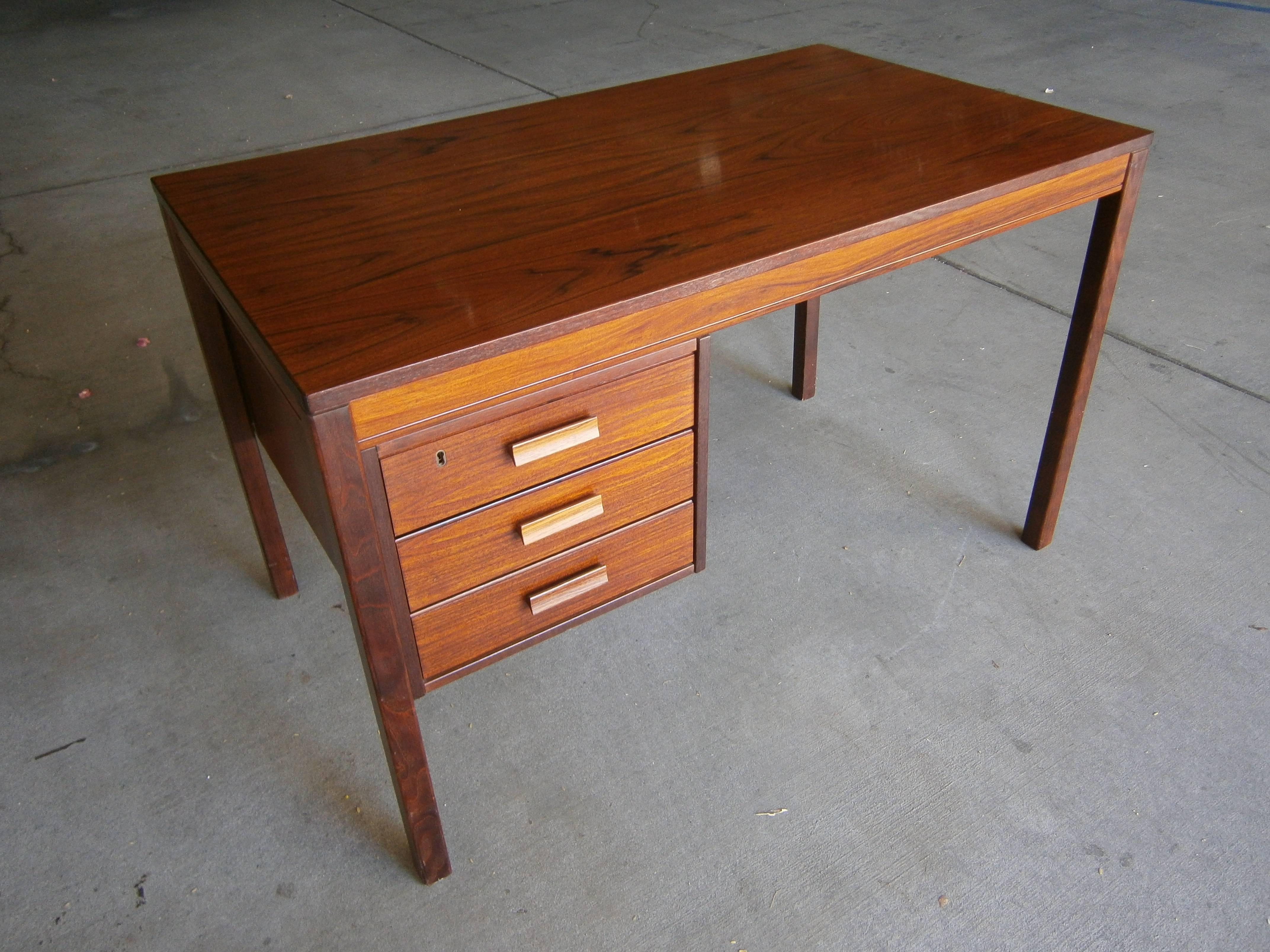 A 1970s Norwegian rosewood writing table with three drawers.