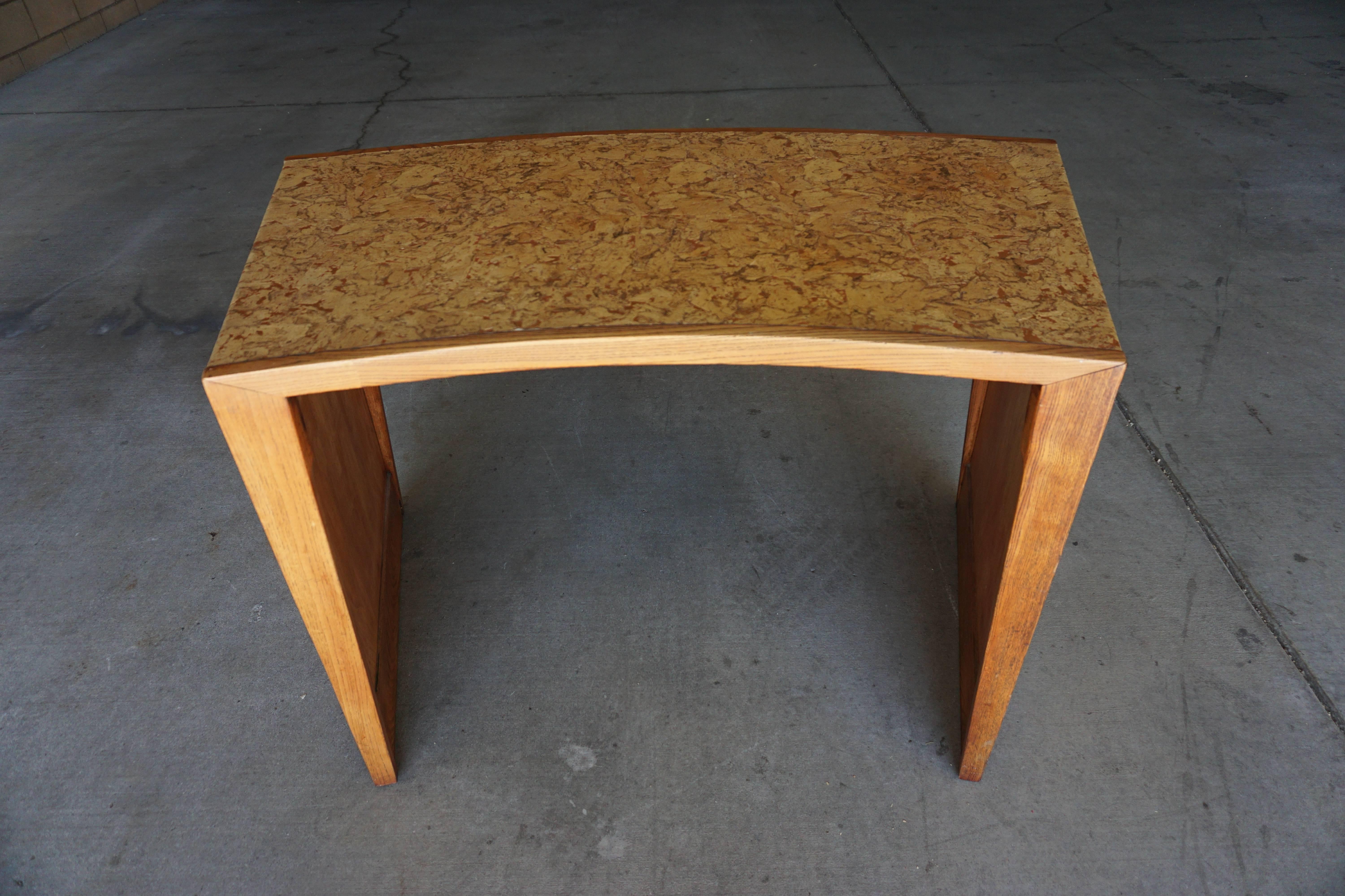 A 1950s curved writing table from the Steve McQueen residence in the Southridge Estates area of Palm Springs. The table is very much in the style of the renowned designer Paul Frankl in the 1950s. The wood on the table is oak. The oak has been
