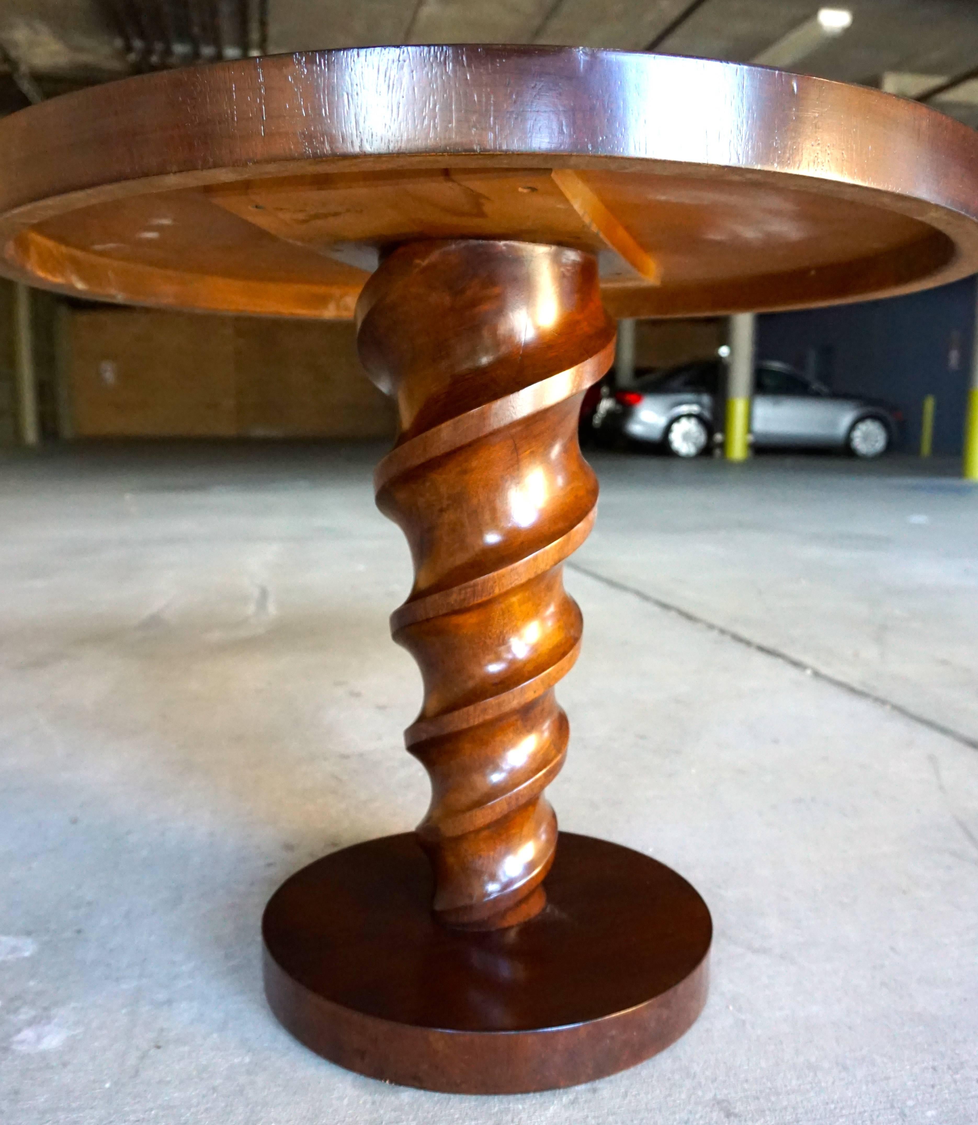 A rare circular side table with a carved "corkscrew"column support designed by Dutch designer Johan Tapp for his furniture company, Tapp Inc. Circa 1940s. The round top and plinth base is veneered in walnut parquetry and the column is