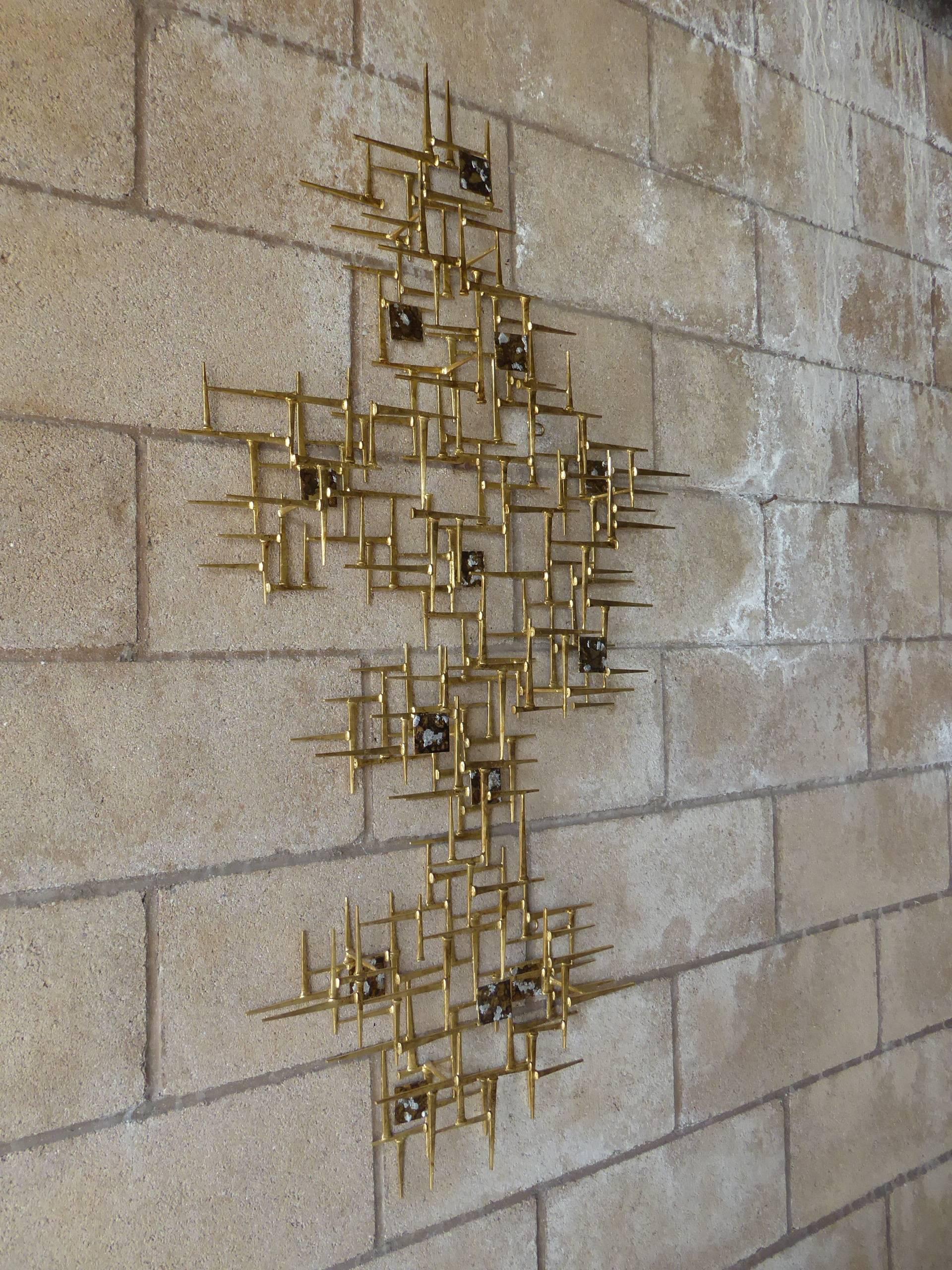 A contemporary gilded steel asymmetrical wall sculpture by American artist Del Williams. Incorporated into the sculpture are metal tiles that have been gilded, patinated and highlighted with silver leaf. The wall sculpture can be hung either