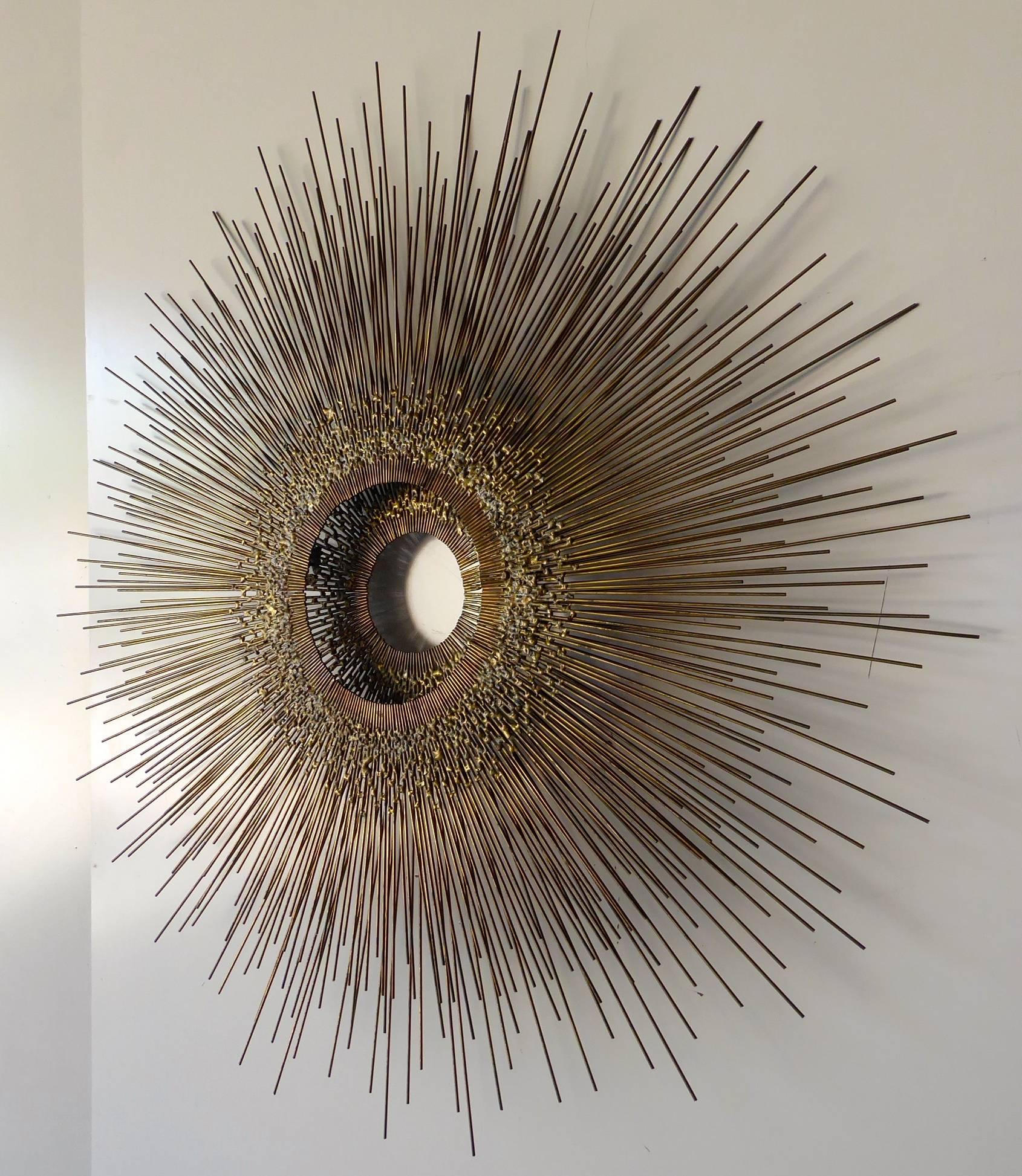 A patinated brass Brutalist starburst wall sculpture attributed to American artist William Friedle, circa 1960s. The sculpture is two layers deep, with the back section having a smaller diameter opening than the front to create an interesting