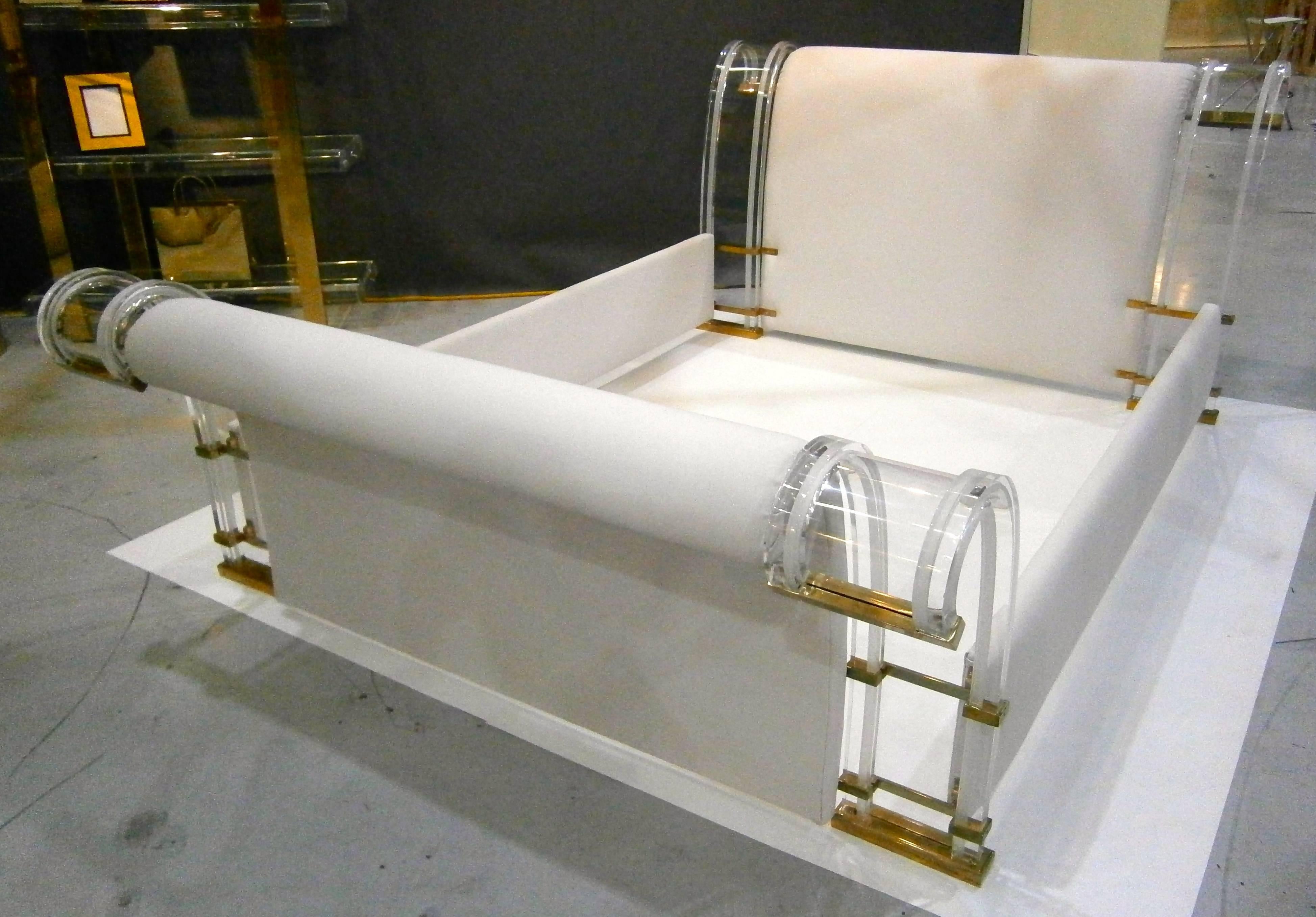An amazing Lucite framed queen sized sleigh bed with solid brass fittings, attributed to Italian furniture designer Marcello Mioni. The bent Lucite pieces that frame the headboard and footboard have a frosted line detail that accentuates the