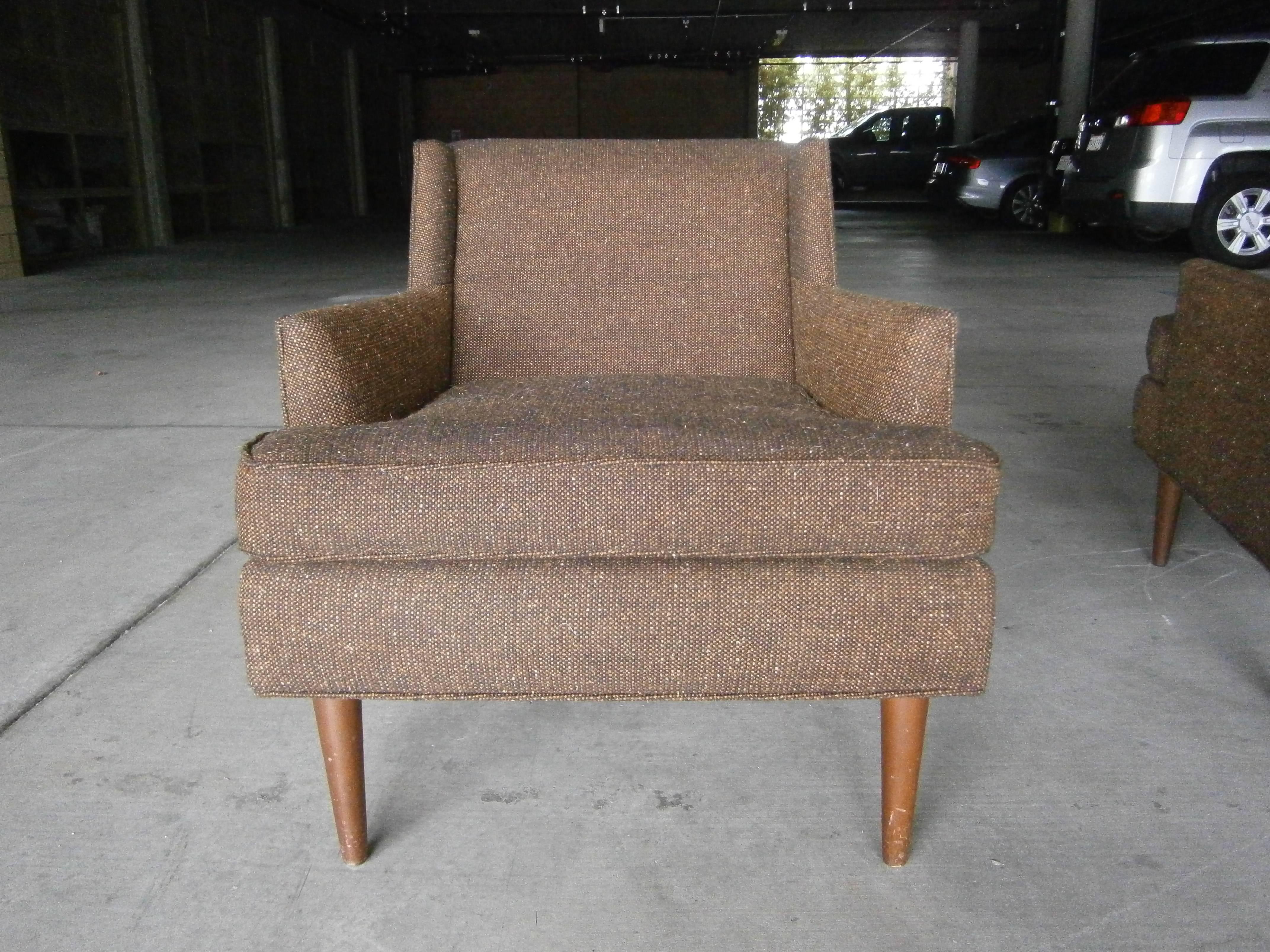 An intriguing set of two fully upholstered Mid Century Modern armchairs from the 1950s. Referred to as 