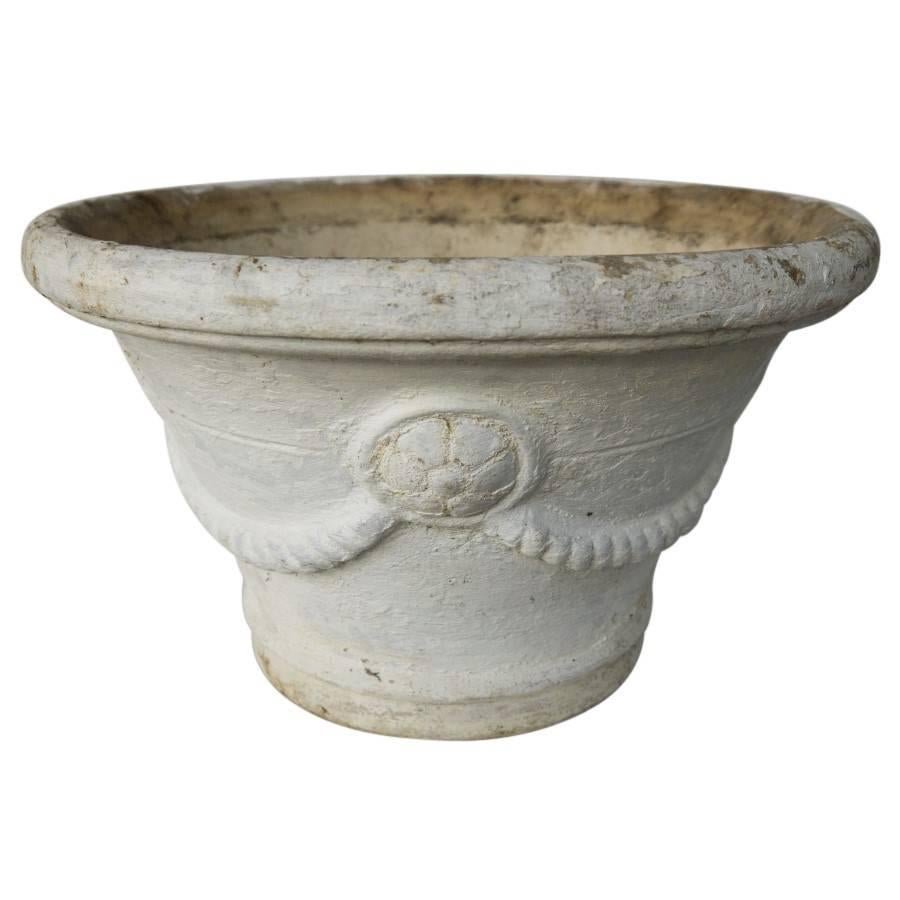 Vintage cast cement planters crafted, circa 1960 in France. The style of the Louis XVI era art movement shown in the embossed rope clasping circled flower pedals. This era in French art marked the beginning of Neoclassicism, and a return to a