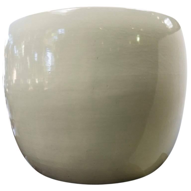 A modern white cylinder with a smooth curved body and a glossy shine of glaze. This is a planter that will blend well with any interior garden design, standing 14 inches tall and 19 inches in diameter at its widest point. Lightweight and elegant
