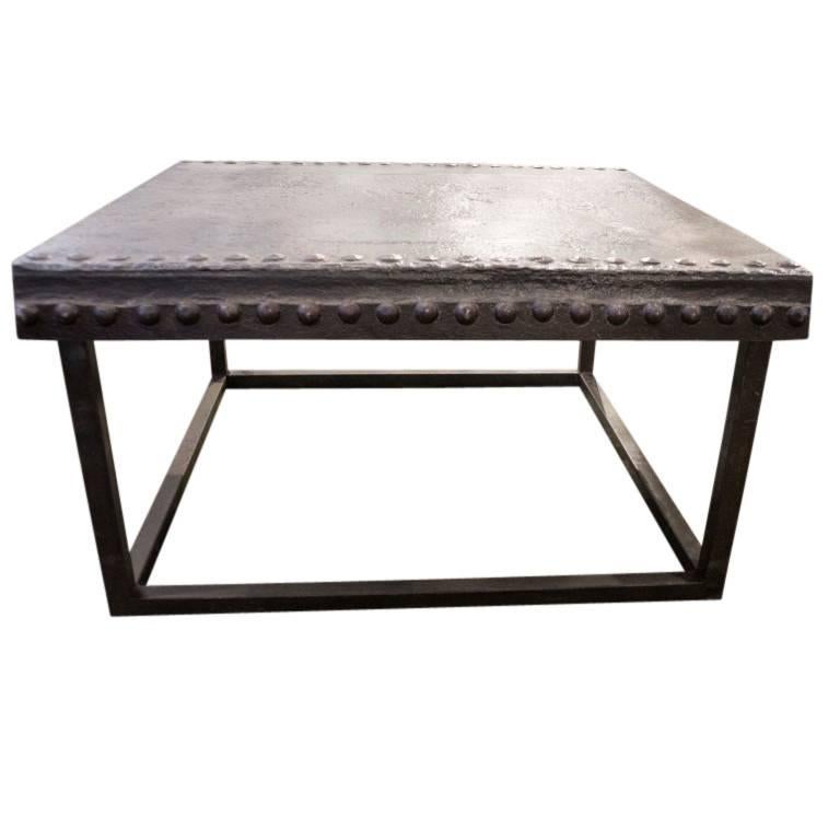 A truly rare and handsome table, this vintage French import is made of iron that with its age and texture, appears warmly brown like fine leather. A nearly three foot square surface area levelled at 18.5 inches high sizes this table for a large end