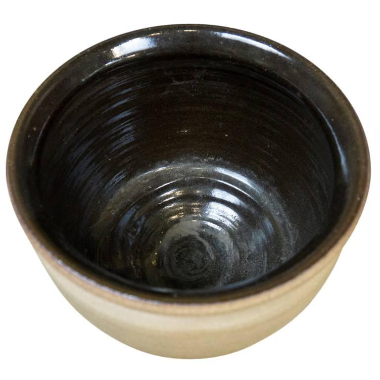 With the earth tones of un-glazed clay outside and a smooth coat of black glaze inside, this vintage planter merges modern design with nature. Standing just over seven inches tall and with a nine inch diameter this modest size tabletop planter from