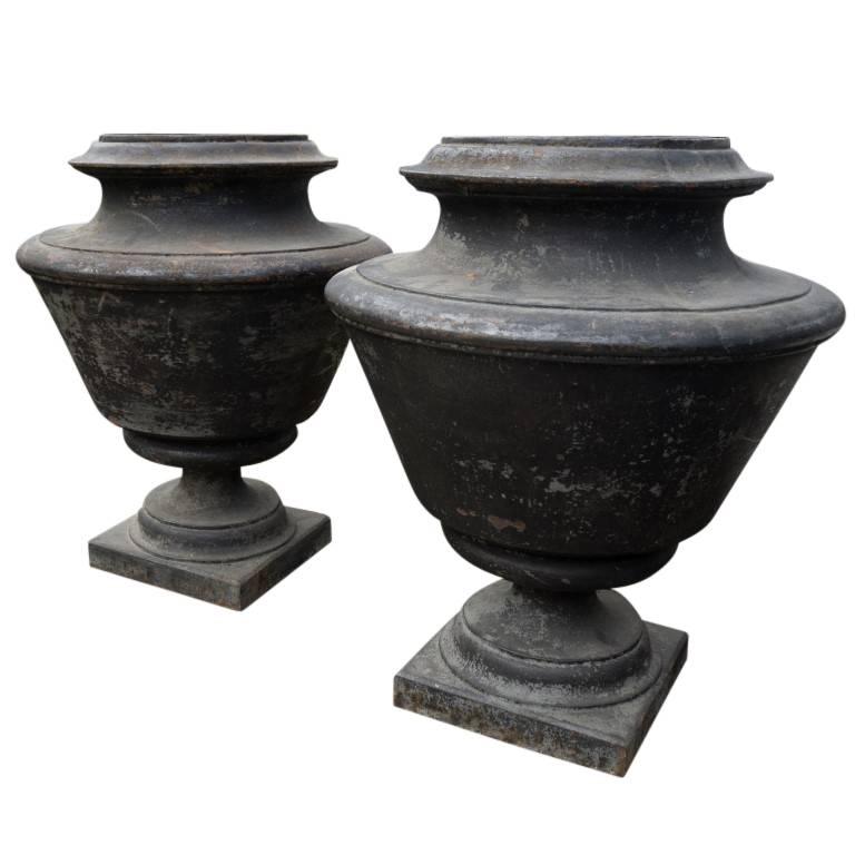 Stunning and elegant, this pair of master-crafted cast iron urns from the year 1870 are an example the class and style of centuries old French gardening tradition. As captivating as classical music the size and shape of these urns are a sight of