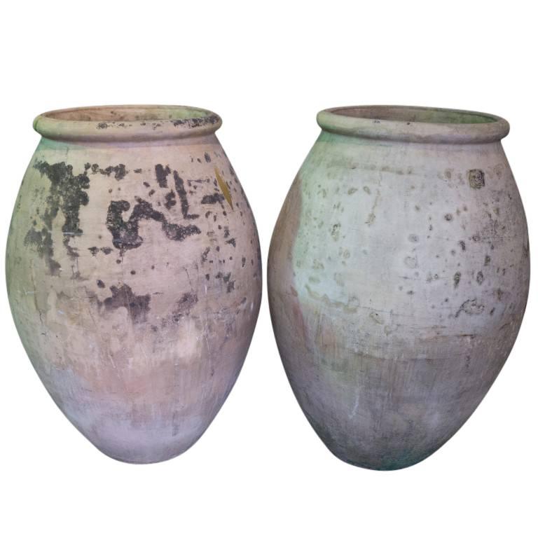 This pair of French made antique terracotta jars are rather large examples of the traditional Biot. Standing just over 3 feet tall with an outer diameter of 27 inches, featuring a smooth curved tapered body and the well rounded top lip