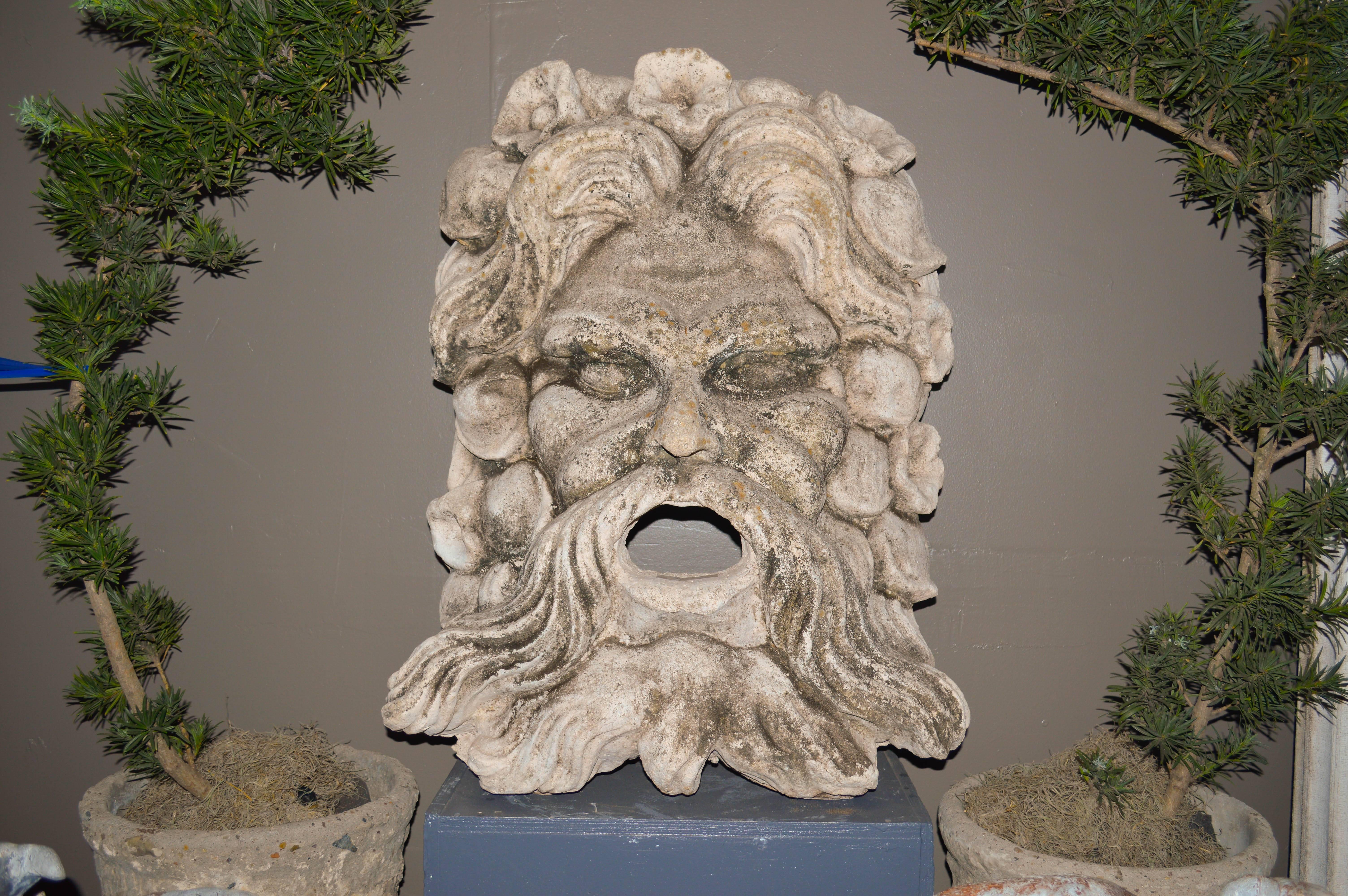 Cast stone mask fountain of Neptune of the sea.