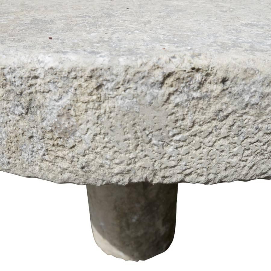 French garden table of substantial size and weight. The circular tabletop made of stone is four inches thick and is supported by a 12 inch thick smooth rounded column. This simple design dates back to the middle ages where stone tables supported by