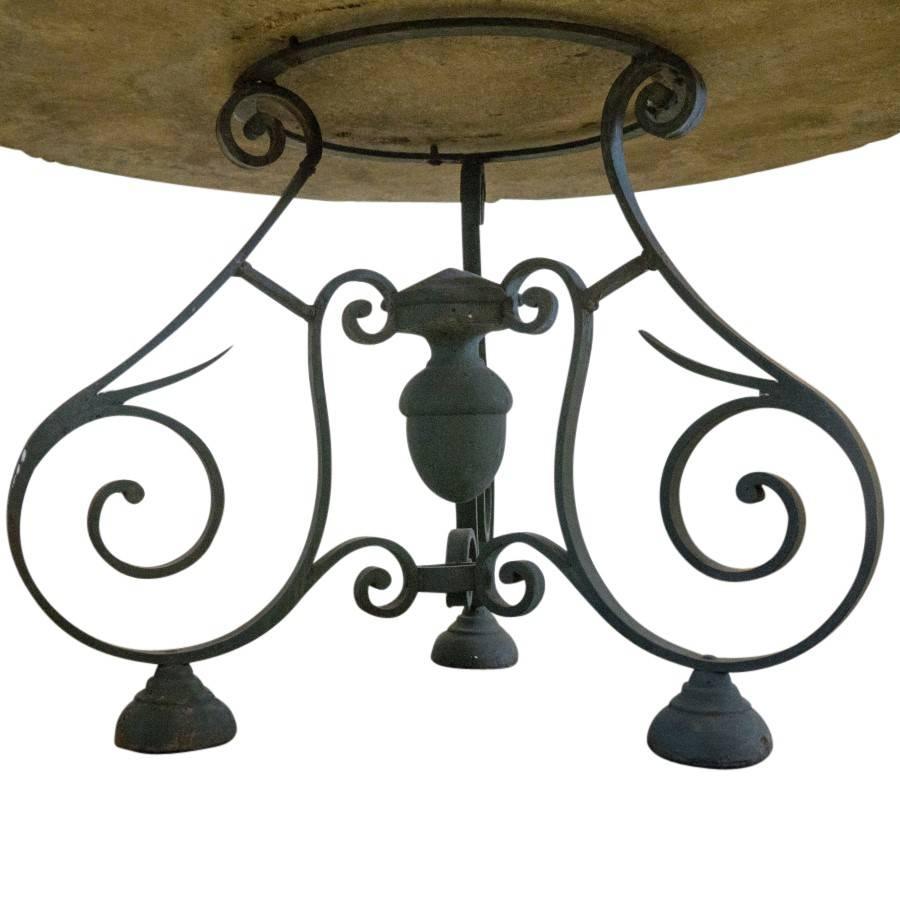 French antique coffee table for your patio or garden, circa 1920, the stone top is two and a half inches thick of a lovely grey and charcoal speckled rock. The iron base is shaped with three thin legs, finely curved spiral accents, atop bell shaped