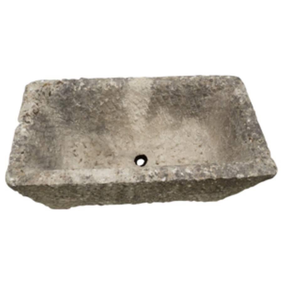 Handsome and heavy, this antique French trough style planter is carved from stone and has a timeless natural beauty. Handcrafted, circa 1800, the trough is a modest size at 31 inches long, 16 inches wide and 14 inches tall. At over two hundred years