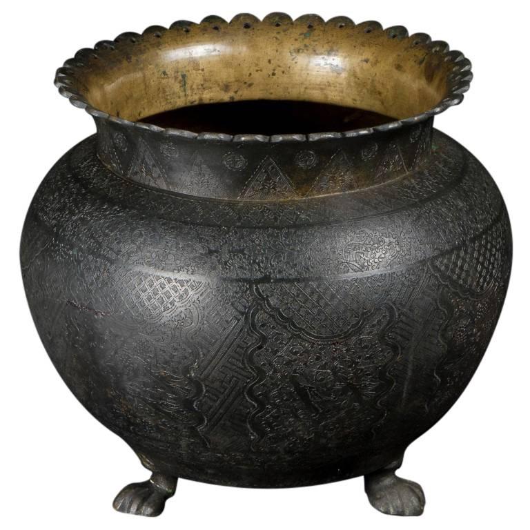 Antique home and garden planters give a space a charming personal touch. This handsome and unique bronze tripodal planter was originally used as a ceremonial vessel. Formed in the 19th century, displaying the style of the Chinese culture in Java,