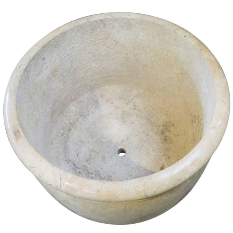 Created circa 1950 this Indonesian marble vessel is awe inspiring. Standing 21 inches tall and 28 inches in diameter with a perfectly rounded base and smooth decorative top makes this planter ideal for showcasing rare or uniquely trimmed vegetation