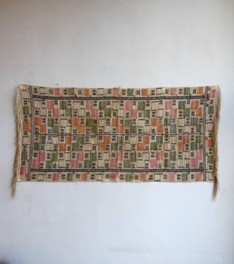 Handwoven linen textile by Marta Maas-Fjetterström made before 1942.

The pattern has dark green, orange and pale violet red square formations, whose regular but asymmetrical repetition create an arrow-like shape, a recurrent theme in Marta's