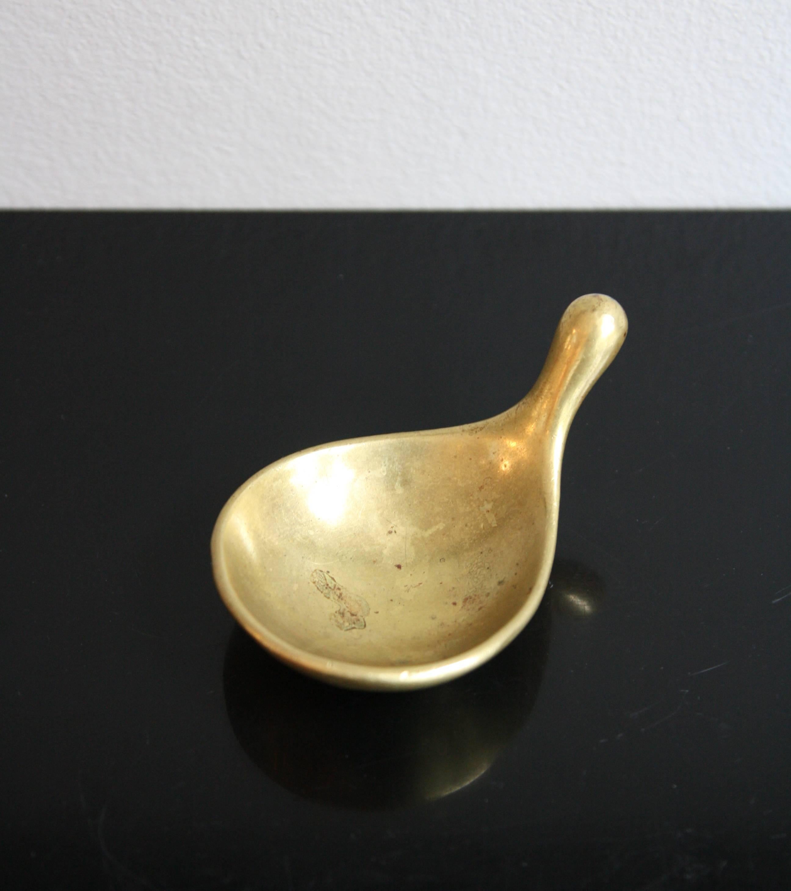 A vintage late-1940s or early-1950s solid cast brass ashtray designed and made by Carl Auböck II in Vienna, Austria. The petite ashtray is extremely organic in shape and tactile, it becomes obvious on picking the piece up that it is meant to be