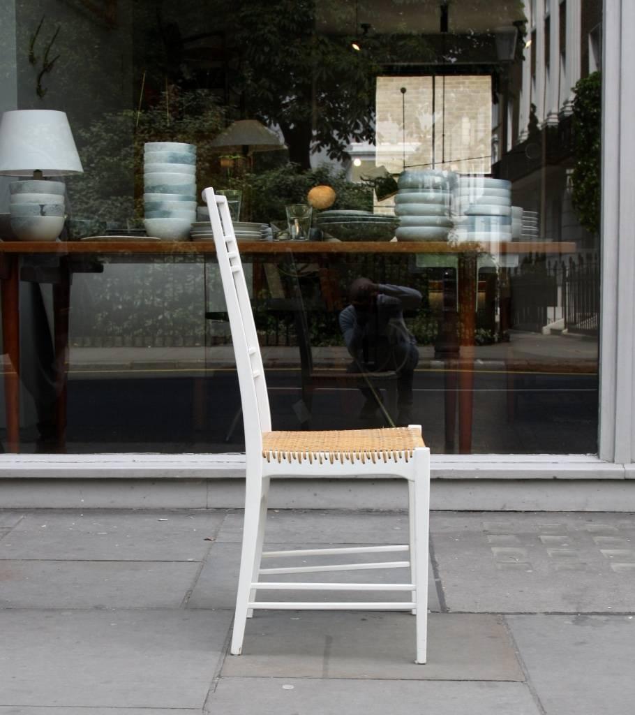 Poem chair designed by Erik Chambert in 1950s. Birch frame painted in white with a wicker seat. Slender and light, overall in very good condition.
 