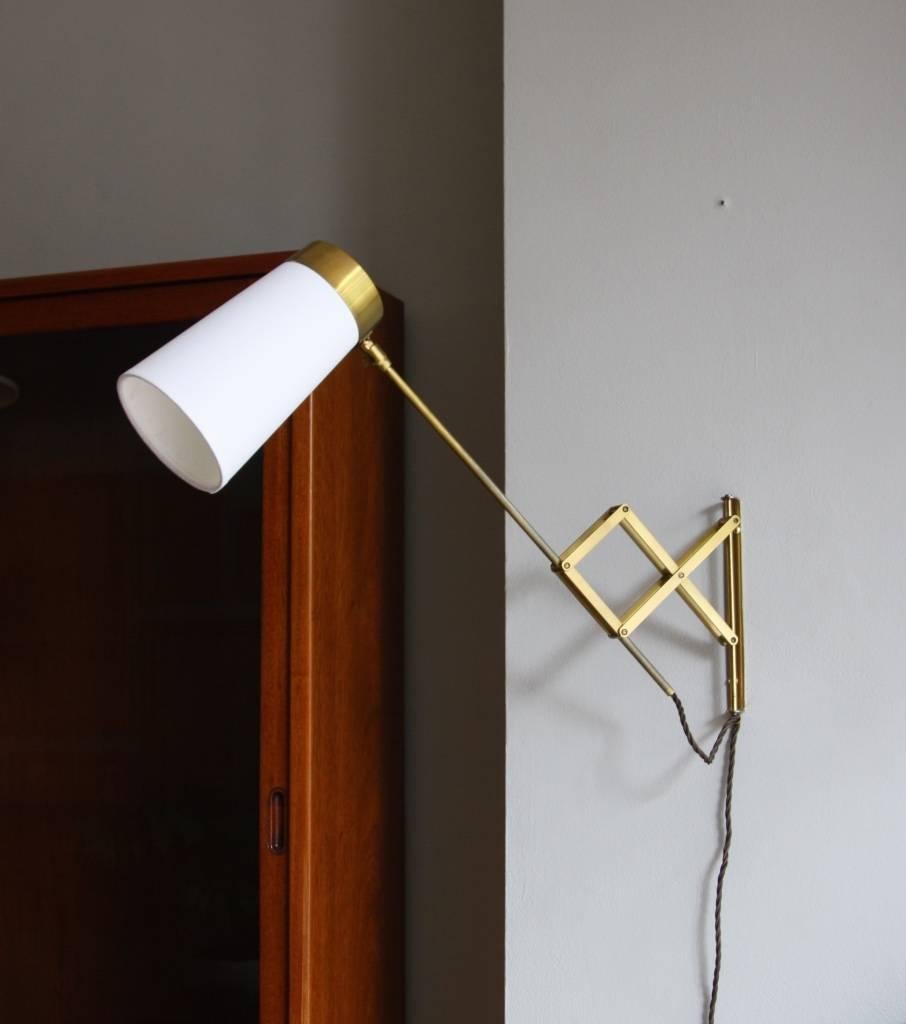Concertina wall light in polished brass, with a newly made shade in copper coated steel covered in white cotton, Denmark, circa 1950.
The adjustable head and the arm extendable make the light a great reading or bedside lamp.
Rewired for the UK, it