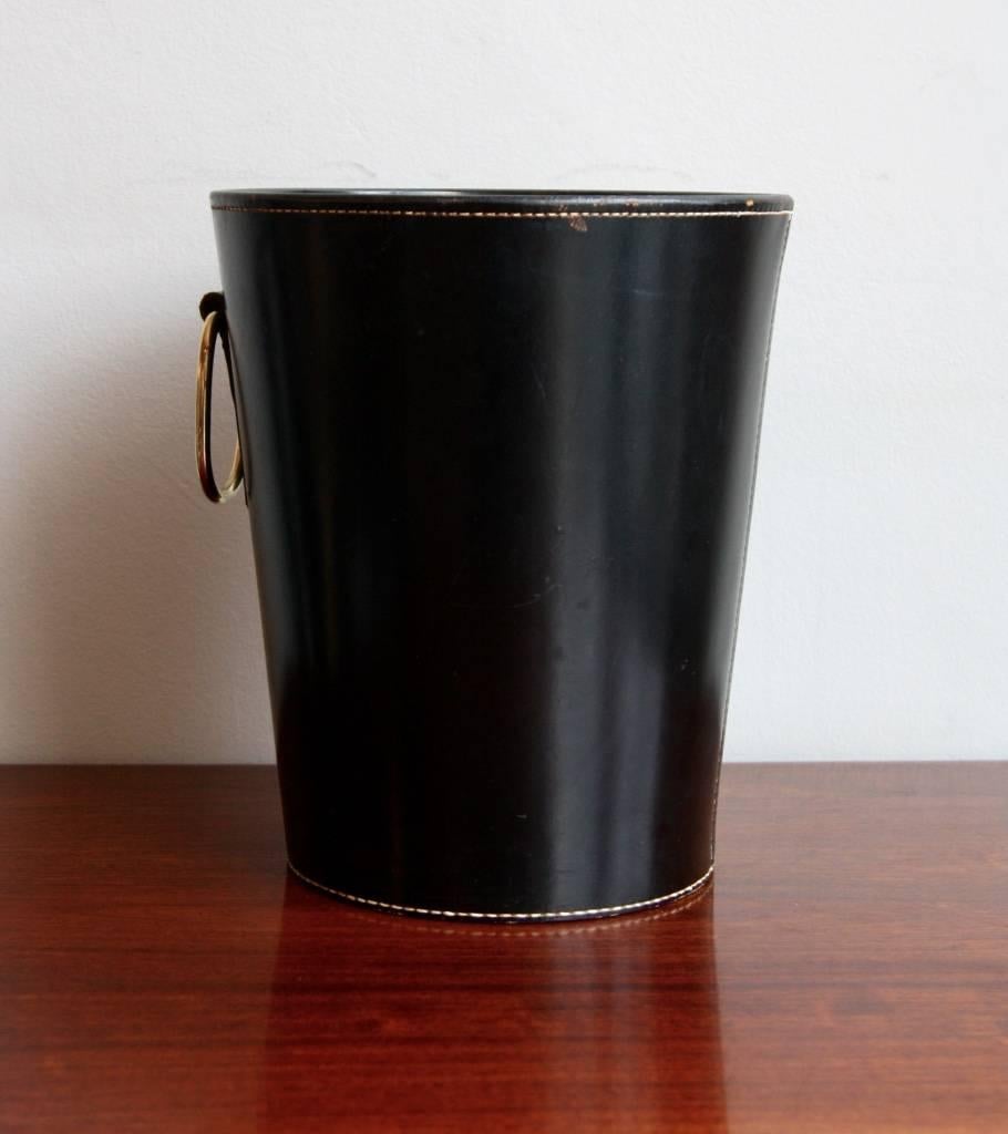 Vintage paper basket manufactured in the 1950s in the Auböck werkstätte in Vienna. The basket is made of two pieces of leather sewn together with white stitching and has a polished brass handle. In excellent condition.