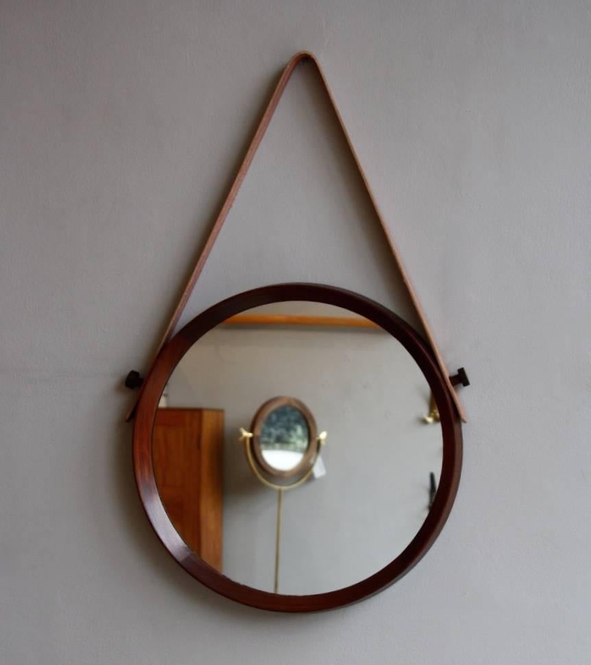 Round wall mirror with a solid mahogany frame and leather strap. Designed and made in Denmark during the 1950s, in perfect condition.