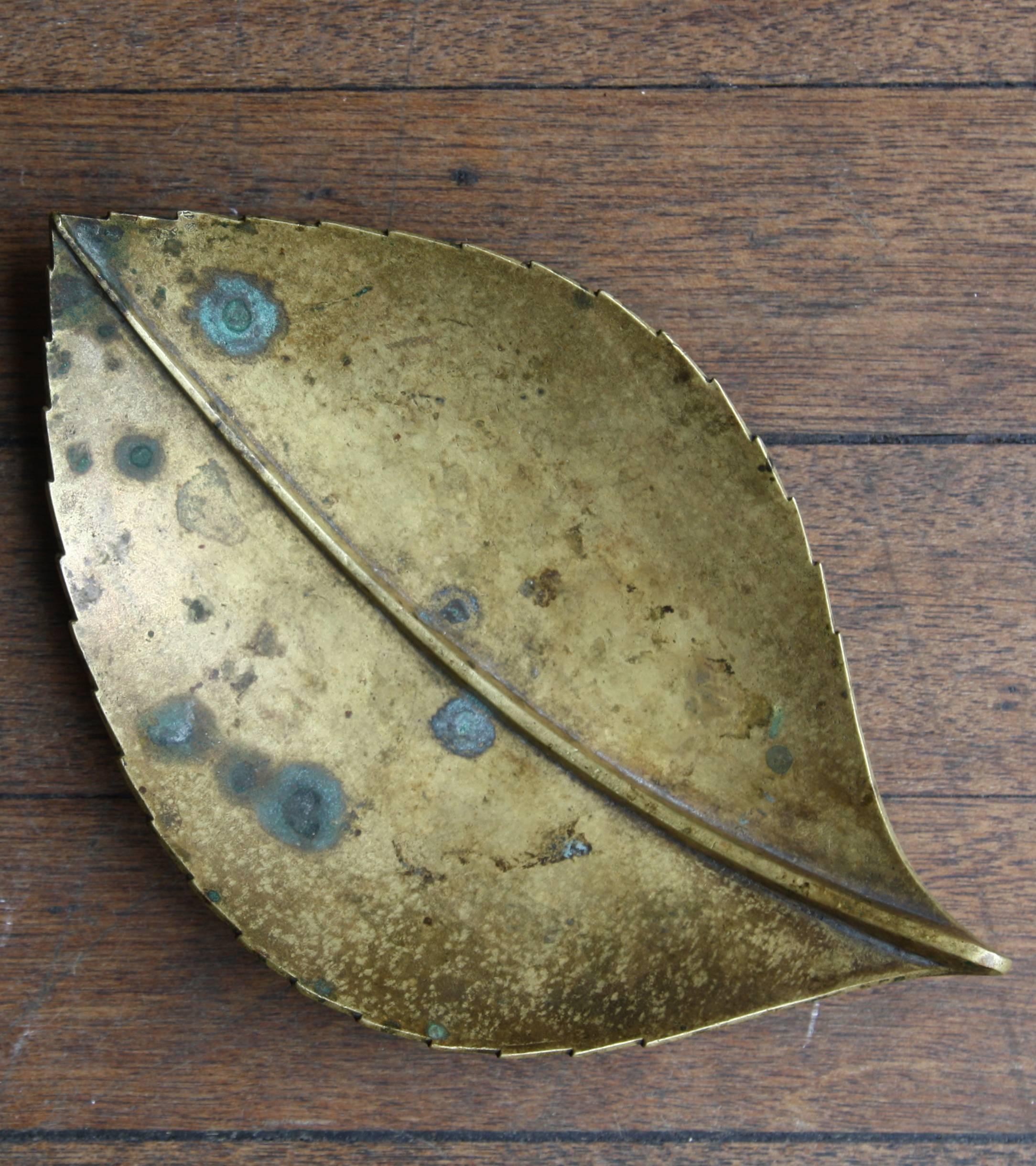 A vintage leaf shaped ashtray designed and made by Carl Auböck II in 1937. 
Although cast in solid brass the design has a lightness and delicacy thanks to the realism of the curves captured in the leaf.
The midrib and blade of the leaf are