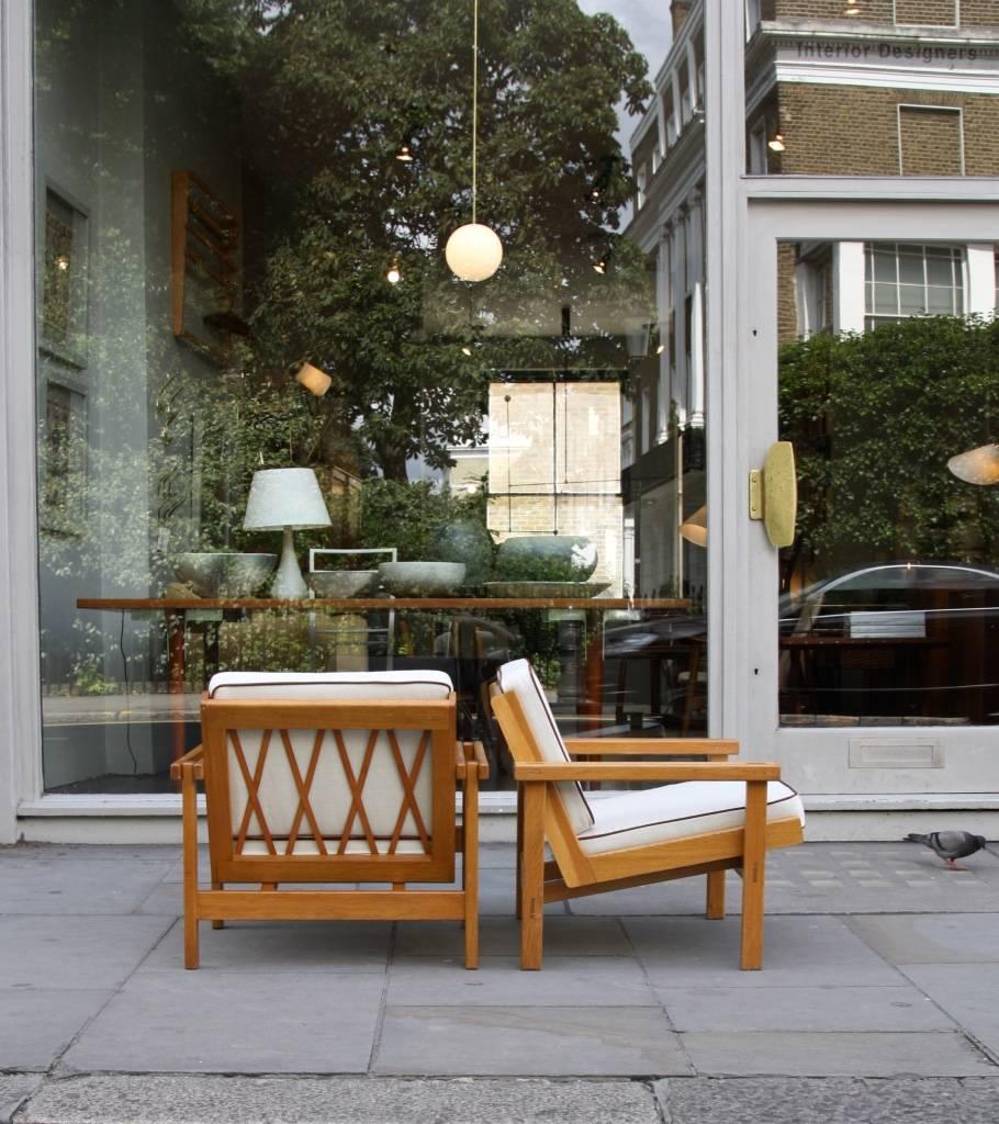 A pair of 1950s armchairs designed by Carl-Gustaf Hiort af Ornäs, Finland, circa 1957.
Although made exclusively of solid oak planks, the chairs' frames are wonderfully light and airy thanks to the space between the armrests and their open backs.