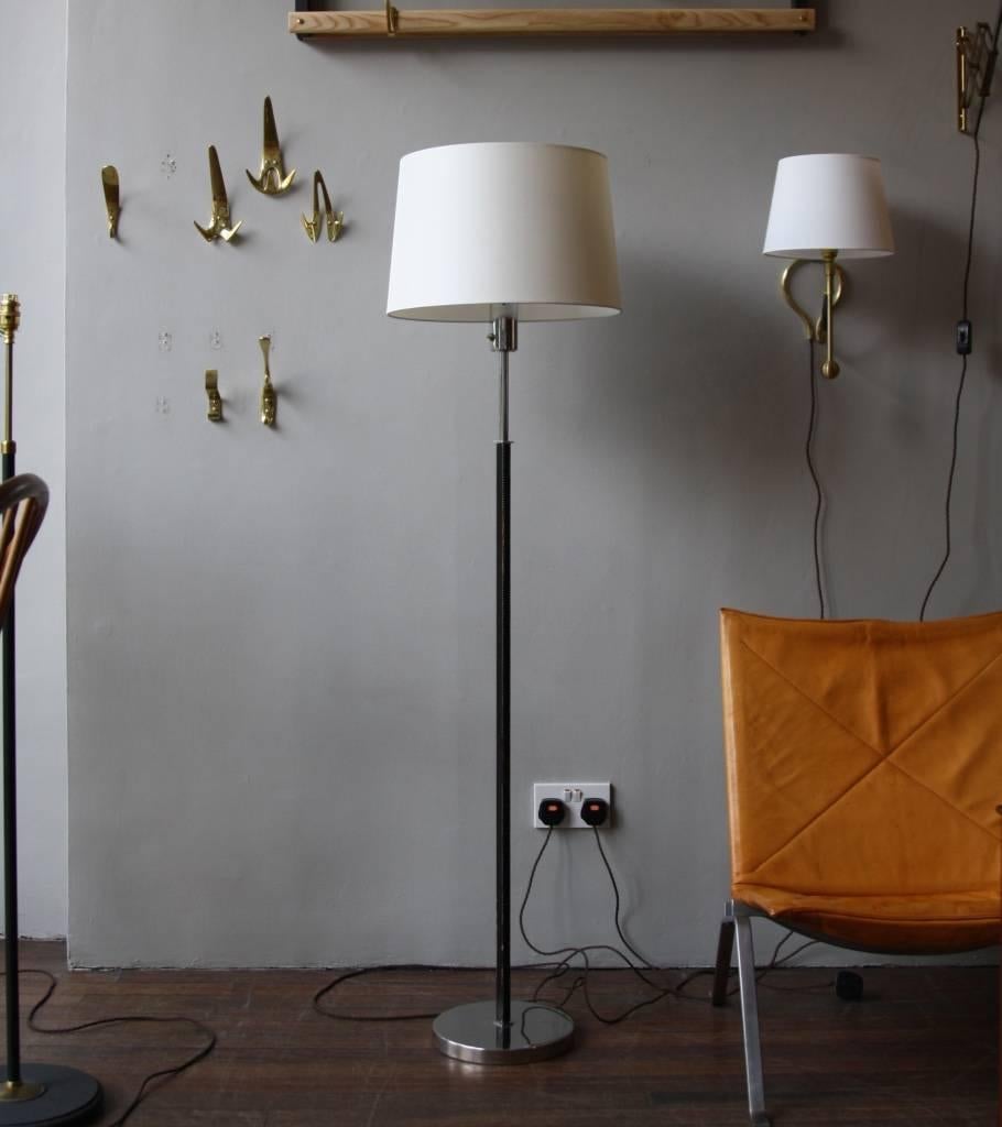Leather and steel floor lamp made in Denmark in the 1950s.
The stem is covered in black leather, the circular base and the bulb holder are in polished steel.
The shade, cylindrical and oyster in color, has been remade in silk.