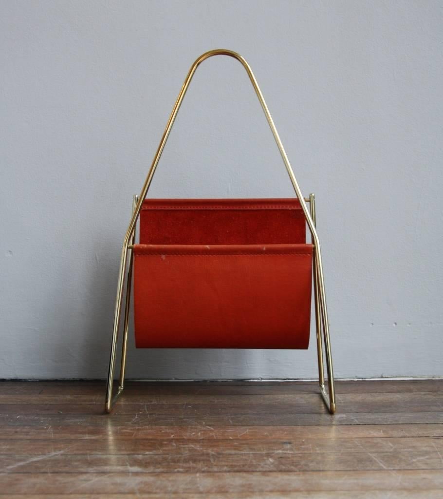 Vintage 1950s magazine stand designed and made in the Auböck Werkstatte, Vienna.
A popular design by Carl Auböck II, rare to find in the hand-sewn original red colored leather.
The curvy frame is in polished brass.
In overall excellent condition.