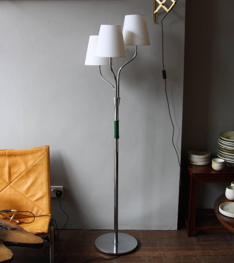 Three-armed floor lamp designed and made in Sweden in the 1960s.
The circular base, the arms and the stem are in polished steel, while the insert is in green colored leather. The organic shape is reminiscent of Joseph Frank designs for Svenskt Tenn
