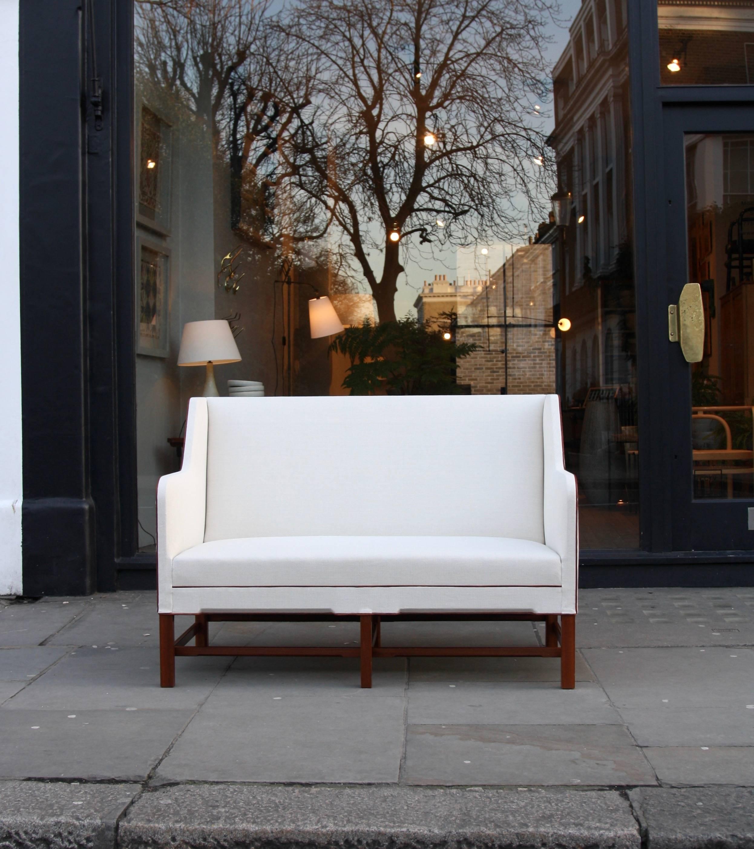 A two-seat 4118 settee designed by Kaare Klint and made by a master cabinetmakers Rud Rasmussen in Denmark, circa 1940. The exquisitely sharp yet flowing lines of the sofa make the high-level of consideration gone into its design and the quality of