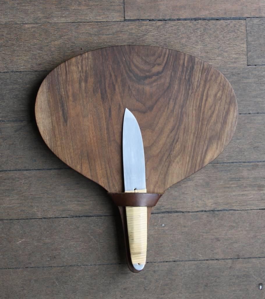 Vintage cutting board with knife by Carl Auböck II, Vienna, circa 1950.
The onion shaped board is made of walnut and boasts a dark brown leather strap to hold the knife, which in turn is in stainless steel with the handle covered in wicker.
Both