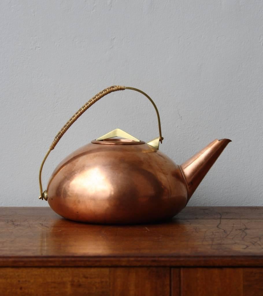 Vintage teapot by Carl Auböck II, Vienna, circa 1950.
The body is made of formed copper with a natural matte patina, the handle and lid handle in cast brass. The handle is covered in braided wicker.
In overall very good condition, stamped Auböck
