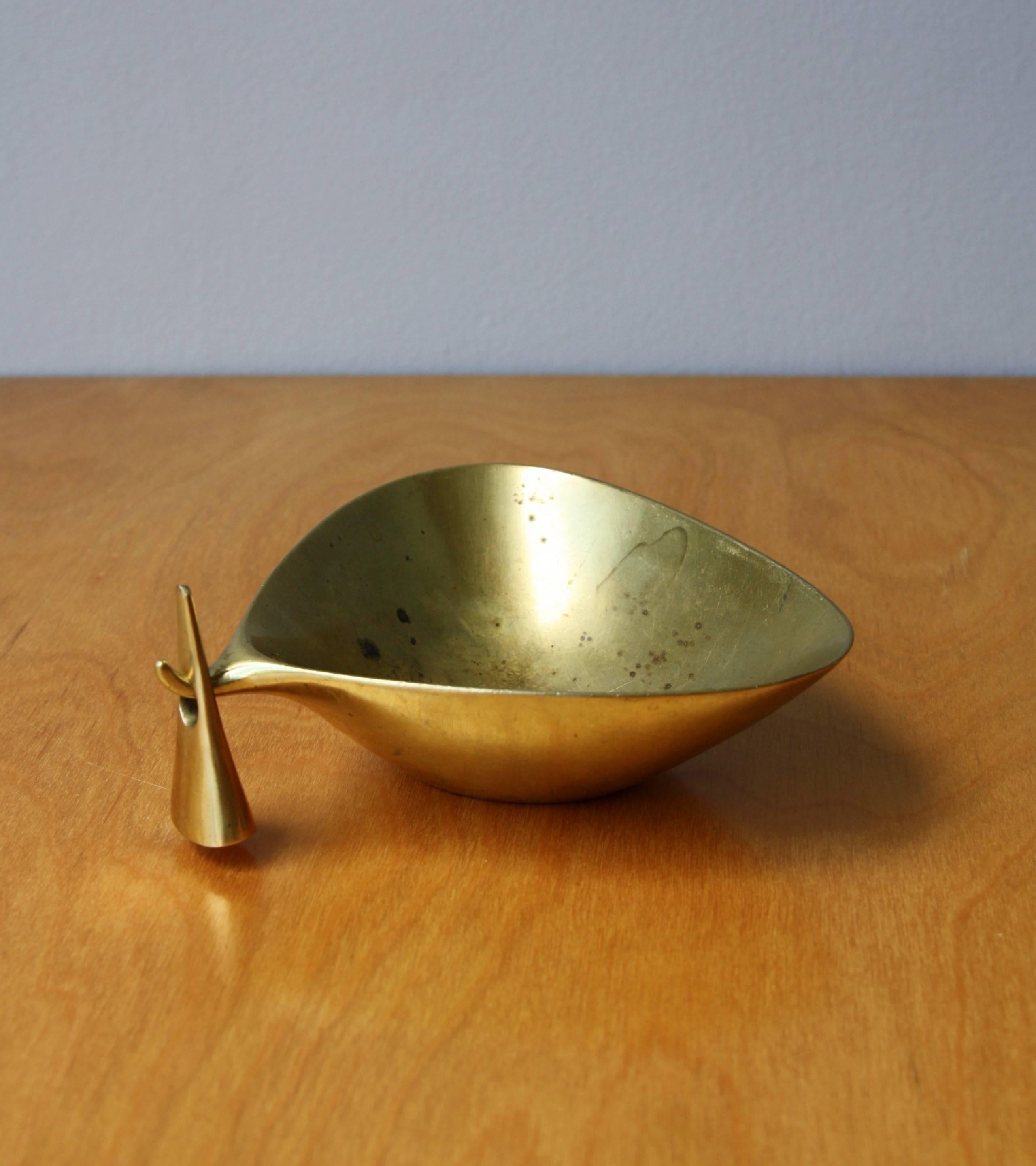 A vintage brass ashtray with tamper by the Auböck Werkstatte, Vienna, circa 1950.
The underside of the bowl is impressed with the manufacturer's mark 'Auböck' and with 'Brown Boveri' on the inside. Brown Boveri is a Swiss group of electrical